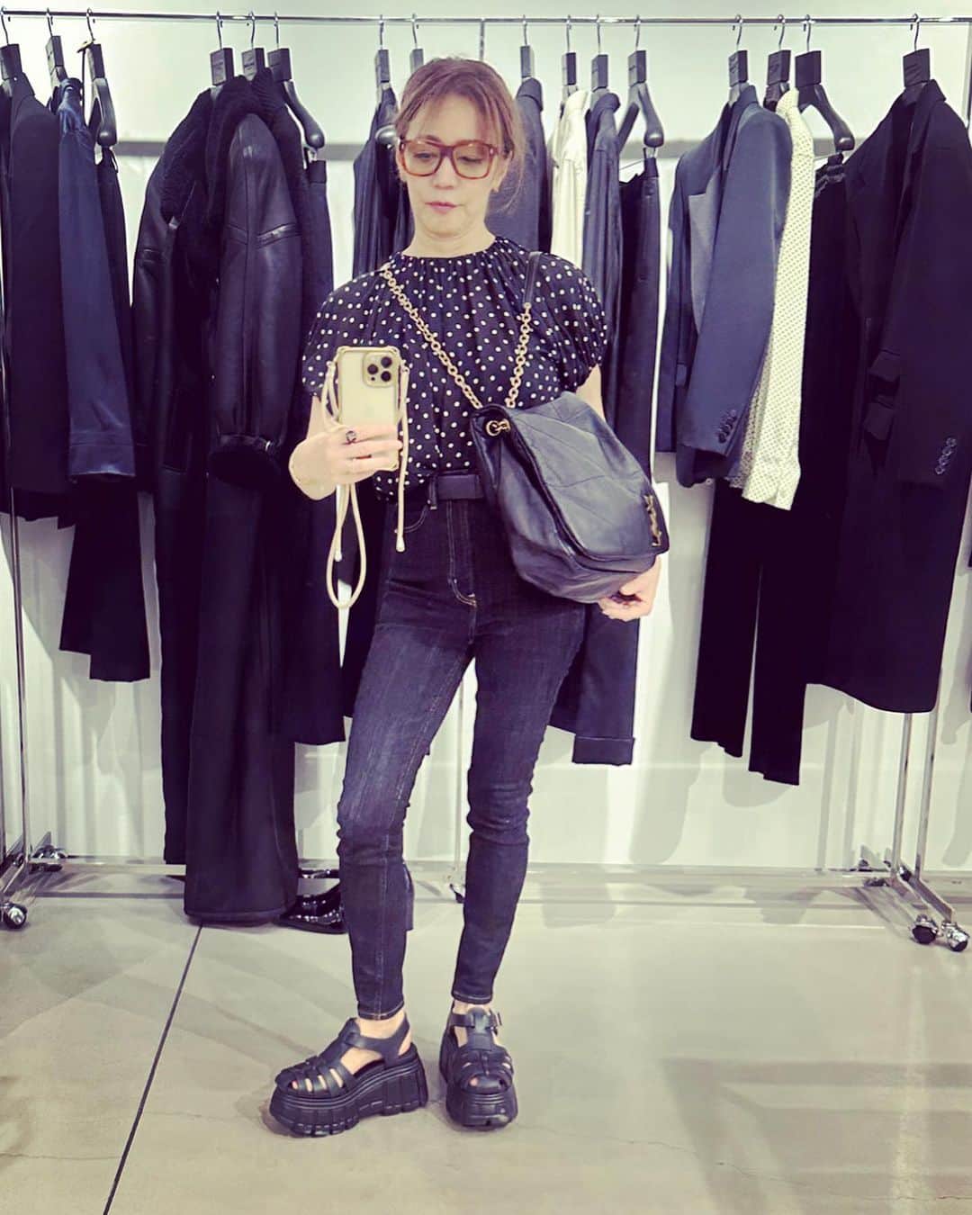 のインスタグラム：「サンローランの展示会場にて。 ショルダーバッグの新しい持ち方をお試し中。この二重クロスボディの持ち方はデザイナーのアンソニーが発案したんだって🎉🎉🎉💕💕  At the Saint Laurent AW2023 open house. Trying out a new way to hold a shoulder bag.This double crossbody way of holding the bag was the new idea of designer Anthony 🎉🎉🎉💕💕.  Great🎉🎉👏👏💕💕💕  THIRD magazineの水玉トップとROLAのブランドSTUDIO R330のスキニーデニム、ミュウミュウのサンダル、新調したGUCCIのアイウエアとともに。」