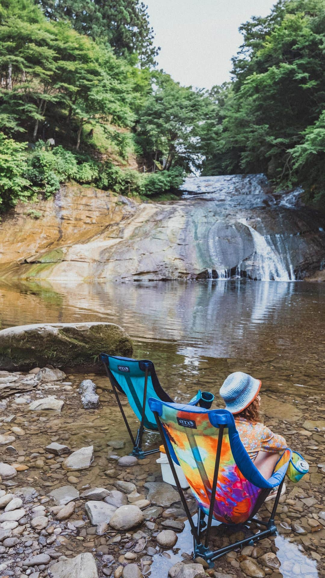 Y U R I Eのインスタグラム：「わたしの推しチェア🏕️🫰🏼 座り心地がまるでハンモックな #loungerDLchair @eno_japan   なんと！新色でタイダイ柄が仲間入り🥹❤️‍🔥 派手好きにはたまらん！！🥳  見た目より軽くて、収納袋までかわいいからフェスにキャンプに、川遊びに色んな所に連れてっちゃおー❗️😆  #enonationjp#ENO#enohammock#hammocklife #chairdesign#outdoorchair#ハンモックチェア#川遊び」