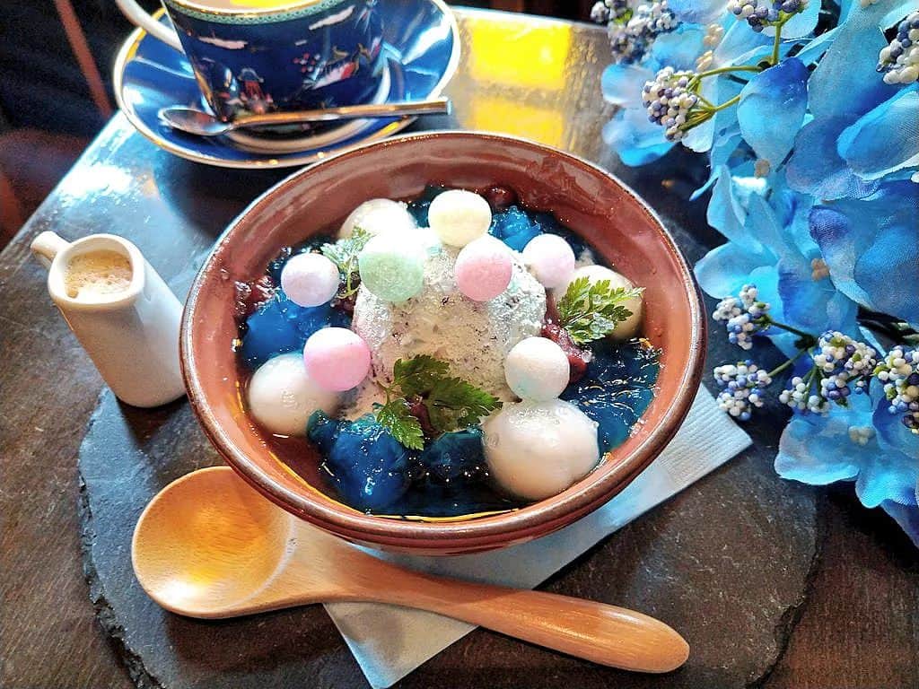 おいもカフェ金糸雀さんのインスタグラム写真 - (おいもカフェ金糸雀Instagram)「. 鎌倉の紫陽花を表現した『あじさいぜんざい』(税込790円)。 冷たいあずきの上に水色のチョコミントアイスや白玉、青いミントゼリーをあしらい、あじさい寺に咲く水色と青の紫陽花をイメージしました。 全体にジュエリーシュガーを散りばめ、雨に濡れるアジサイの艶感を演出。 別添えのコーヒーをチョコミントアイスにかけるとアフォガードの様に味わいが変化します(^^) 爽やかなミントと甘いあずきの組み合わせが絶妙な冷やしぜんざいです♪ . #おいもカフェ金糸雀 #おいもカフェ #鎌倉 #小町通り #湘南 #神奈川 #カフェ #喫茶店 #鎌倉カフェ #湘南カフェ #神奈川カフェ #鎌倉スイーツ #鎌倉グルメ #鎌倉観光 #鎌倉旅行 #鎌倉散歩 #鎌倉デート #あじさいぜんざい #ぜんざい #チョコミント #あずき #スイーツ #チョコミントスイーツ #チョコミン党 #白玉 #おいり #紫陽花 #レトロ #kamakura #가마쿠라 . 《おいもカフェ金糸雀》 営業時間：10:00-18:00(L.O.17:30) 定休日：水曜日 248-0006 神奈川県鎌倉市小町2-10-10 小町TIビル1F TEL：0467-22-4908」6月28日 22時02分 - oimocafekanaria