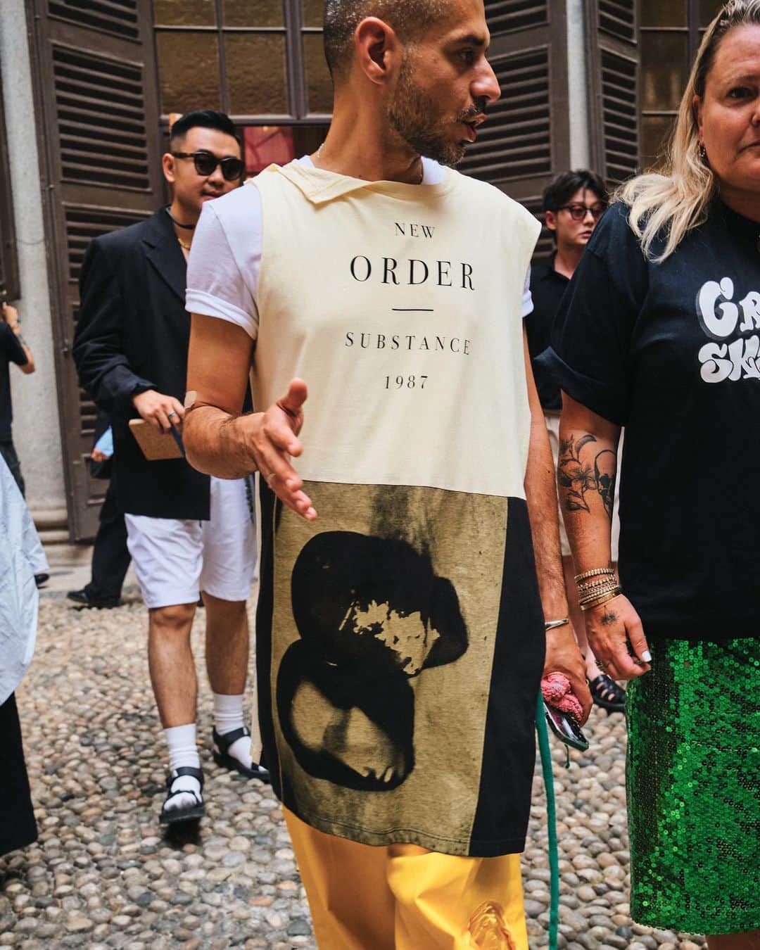 New York Times Fashionさんのインスタグラム写真 - (New York Times FashionInstagram)「Outside the men’s wear shows in Milan and Paris this month, fashion insiders showed up in inventive looks that included three-piece suits and graphic tees. Pharrell Williams, the new Louis Vuitton men’s creative director, wore a Kenzo jacket-and-shorts set.  The photographer @simbarashecha spent 10 days observing the fashion on the streets of Milan and Paris, where neck scarves were a potent accessory and the few who had traditional neckties wore them atypically, including with collarless shirts.  “It’s not a stretch to say that men’s wear has long been seen by many as simpler and less creative than women’s wear,” he writes. “But as more men have found ways to personalize even the most traditional staples, they have shown that there are far wider possibilities than once thought.”  Others on the street revived a fad popularized in the early 1990s by the hip-hop duo Kriss Kross: wearing blazers and shirts in reverse, so the buttons and lapels were on the back. And there were various graphic tops with popular culture references, including a fisherman’s sweater with an image of Kurt Cobain’s face and a sleeveless tunic featuring the album cover of “Substance” by New Order.  See more style outside from recent fashion weeks at the link in bio. Photos by @simbarashecha」6月29日 1時42分 - nytstyle