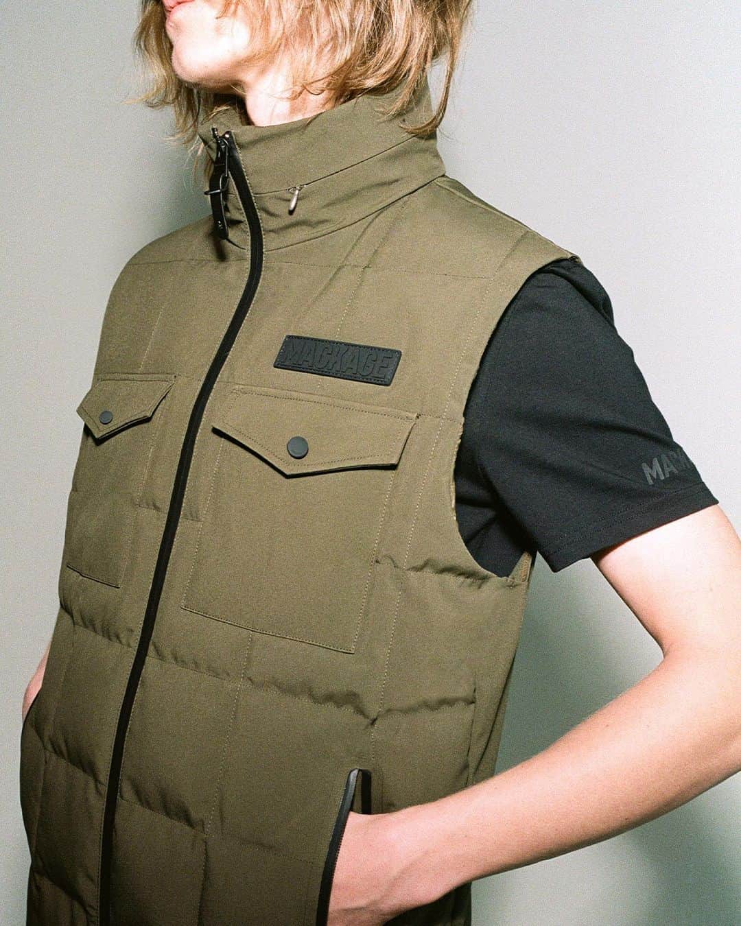 マッカージュのインスタグラム：「HANK, a Flex Tech down vest with a packable hood hidden inside the stand collar. Designed with a water resistant, repellent, and windproof 3-layer tech shell fabric blended with post-consumer recycled yarns with 4-way stretch. Store essentials in chest patch pockets or zip waist pockets. A function-focused essential layer designed for utilitarian comfort.   More on MACKAGE.COM   #MACKAGE #MONDEMACKAGE」