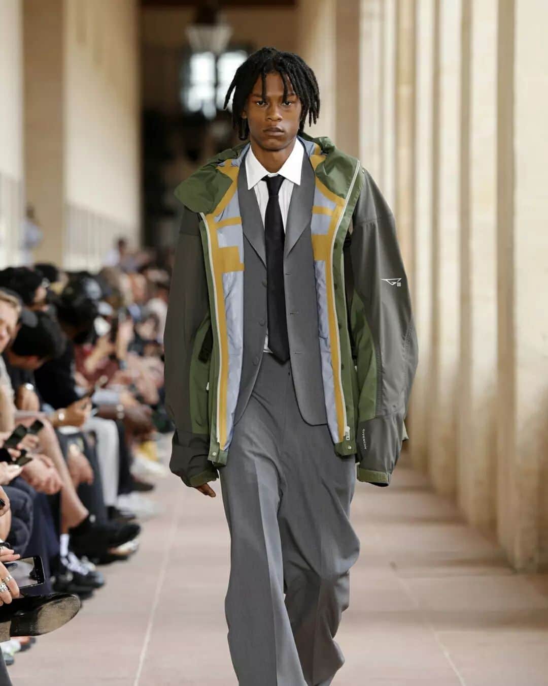 Fashion Weekのインスタグラム：「ICYMI: #Givenchy #SS24 has arrived. Creative Director, #MatthewMWilliams fuses grunge and sportswear with utilitarian suit styles. He is inspired by his teenage son and, in some instances, the looks appear to be a push and pull between the styles of youth and adulthood.   The menswear collection challenges basic comfort-wear with subtle adjustments that empower the wearer. From perforated sweaters, relaxed yet boxy fits, to sports jackets over pant suits, there's much to be discovered.」