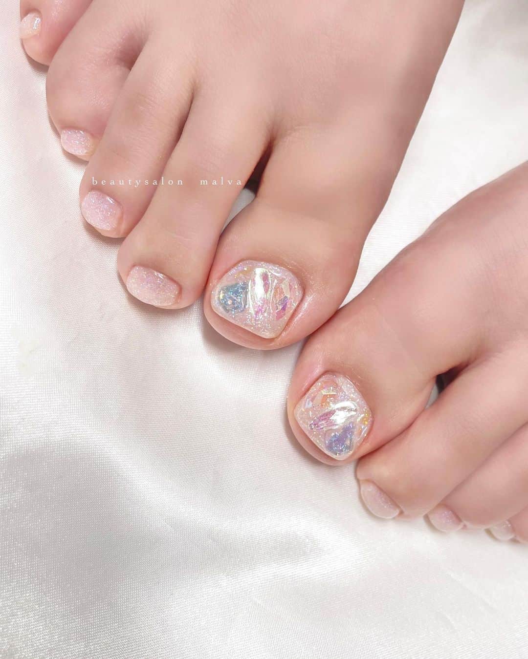 nailsalon malva（ネイルサロンマルヴァ）のインスタグラム：「【フットベーシックプラス201】でご予約🉑 ⁡ これからのフットネイルにおすすめキラキラデザイン✨ ストーンはもちろんですが、 他の指もオリジナルのキラキララメが光ってキレイです💡 ⁡ ハンドとフットSETだとお得にご案内できます♡ 【ハンド&フットSET148】でご予約可能です⭐︎ ⁡ ＿＿＿＿＿＿＿＿＿＿＿＿＿ ⁡ ⁡ 𝐛𝐞𝐚𝐮𝐭𝐲𝐬𝐚𝐥𝐨𝐧 𝐦𝐚𝐥𝐯𝐚⠀ 📍明治神宮前駅｜原宿駅　徒歩𝟑分 ⠀ 💬ご予約やお問い合わせ 𝐋𝐈𝐍𝐄から承っております @ 𝐦𝐚𝐥𝐯𝐚 ⁡ お気軽にご連絡ください♡ ⁡ ⁡ ＿＿＿＿＿＿＿＿＿＿＿＿＿＿ ⁡ ▸ジェルネイル｜スカルプ｜ケア ▸まつげカール｜まつげエクステ ▸ハーブよもぎ蒸し ▸ワックス脱毛 ⁡ ⁡ \ アシスタント募集中💁‍♀️ / ⁡ ▸リモート可オンラインの画像動画制作アシスタント ▸サロンワーク全般アシスタント ⁡ ⁡ ⁡ ⁡ ⁡ ⁡  #偏光ストーンネイル #アイスストーン #フットネイル #malva #malvaネイル #クリアキラキラネイル #フットネイルデザイン #氷ネイル  #nails #原宿ネイル #夏ネイル  #表参道ネイル #東京ネイルサロン　#明治神宮前ネイル #新宿ネイル #千駄ヶ谷ネイル #池袋ネイル #harajukunails #tokyonails #tokyonailsalon ⁡」