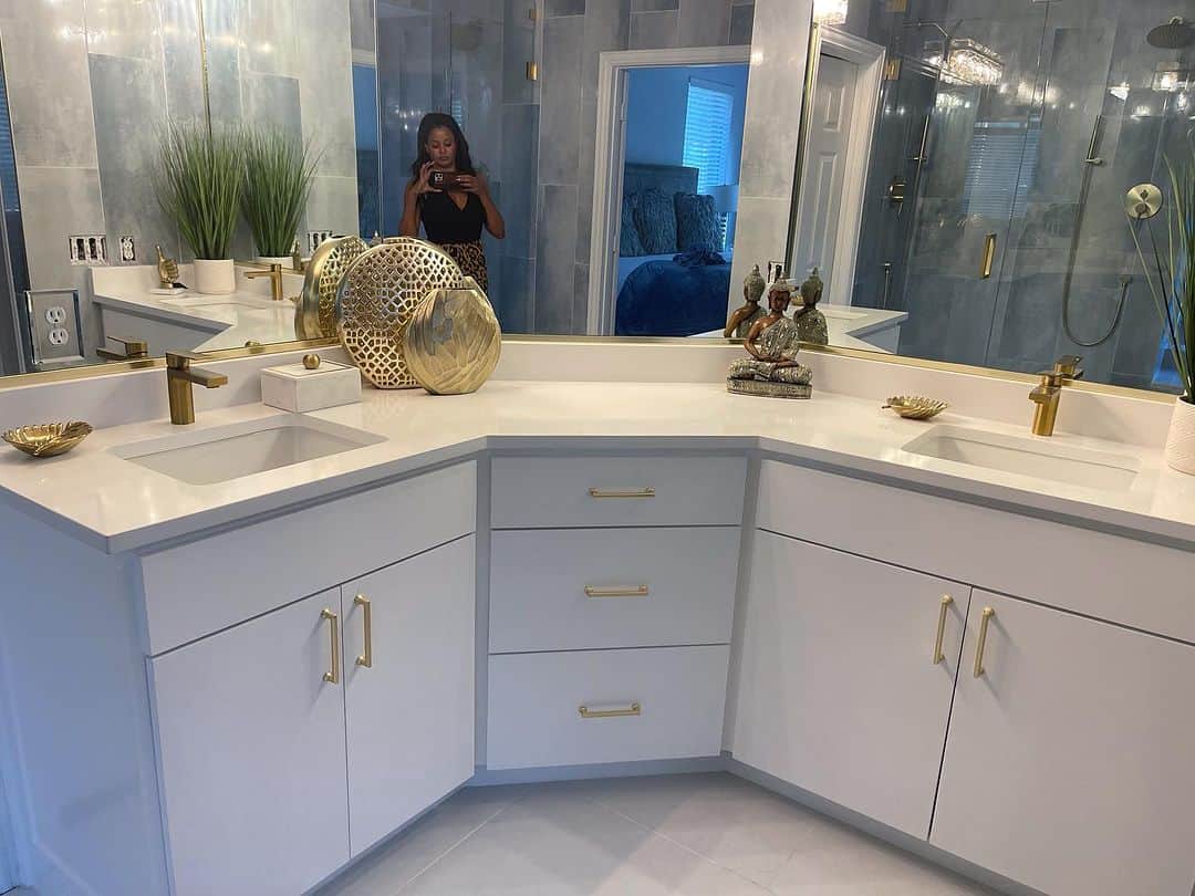 クラウディア・ジョーダンのインスタグラム：「Turned out pretty good 💙  Fully tiled floor to ceiling pale blue walls, custom white cabinets, floors and counter tops; gold accessories. 3 brushed gold shower heads and 8 foot high custom glass shower doors. I 💙 my new and improved bathroom 🙌🏾  Before and after transformation videos coming.」