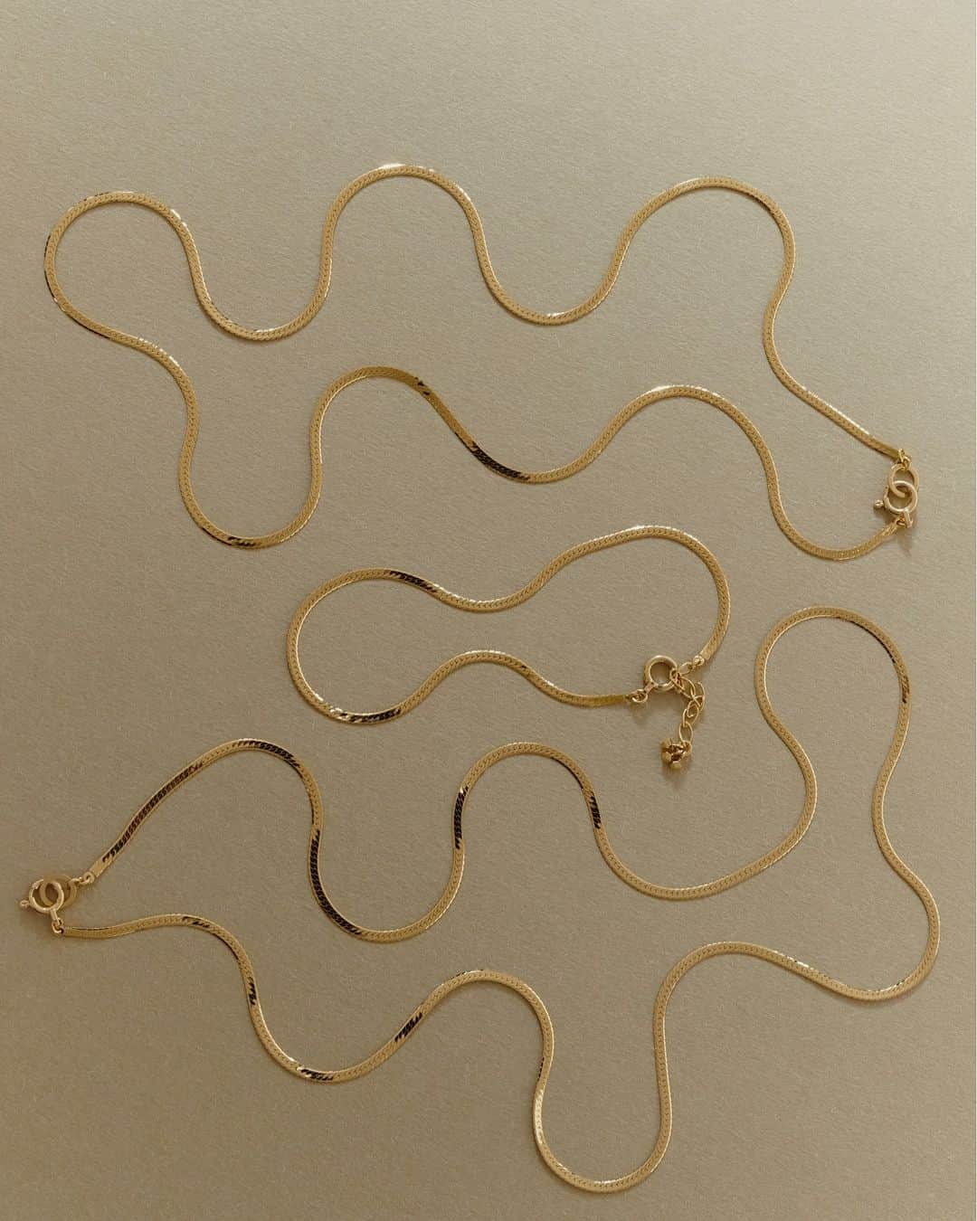 のインスタグラム：「. 7月5日（水）、幸運の象徴をさりげなく纏うことのできるプレシャスなシリーズ「Serpentine」から待望の新作ヘリンボーン ネックレスとブレスレットが発売されます。  神聖な蛇の高貴さを称えた、滑らかな輝きが印象的な新作。フラットで存在感があり、首元や手元からさりげない気品と存在感を放ちます。肌に添うように神秘的に煌めくフォルムは、神々しい「Serpentine」の存在そのものを表すようです。  神話の世界と日常がいつも共にあるように、幸あふれるデザインの新作ヘリンボーンをお楽しみください。  販売店舗：MARIHA伊勢丹新宿店本館 1 階, MARIHA阪急うめだ本店, MARIHA Official Online Boutique  #mariha #marihajewelry #新作ジュエリー #新作ネックレス #新発売 #マリハ」