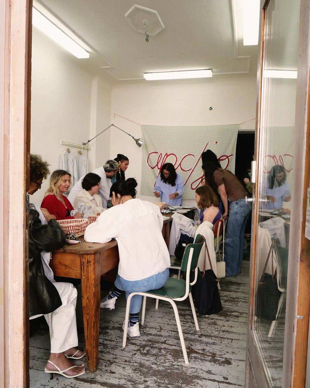 アーペーセーのインスタグラム：「Sewin n' Strummin' Berlin edition.   The Berlin A.P.C. fam joined us at Café Pilz for a workshop with the creative behind our famous quilts, Jessica Ogden @the_cats_whiskers.  A pioneer of the customization movement of the early 1990s and an early adopter of upcycling, Jessica has been drawing and sewing since childhood. After launching her own brand in England, she returned to live in Jamaica, where she grew up. She created the Madras collection with A.P.C. in 2006 and introduced the Quilts project in 2010, born from the interest she shares with Jean for patchwork, as well as a desire to revive the accumulated stocks of A.P.C. fabrics over the seasons.  #APCParis」