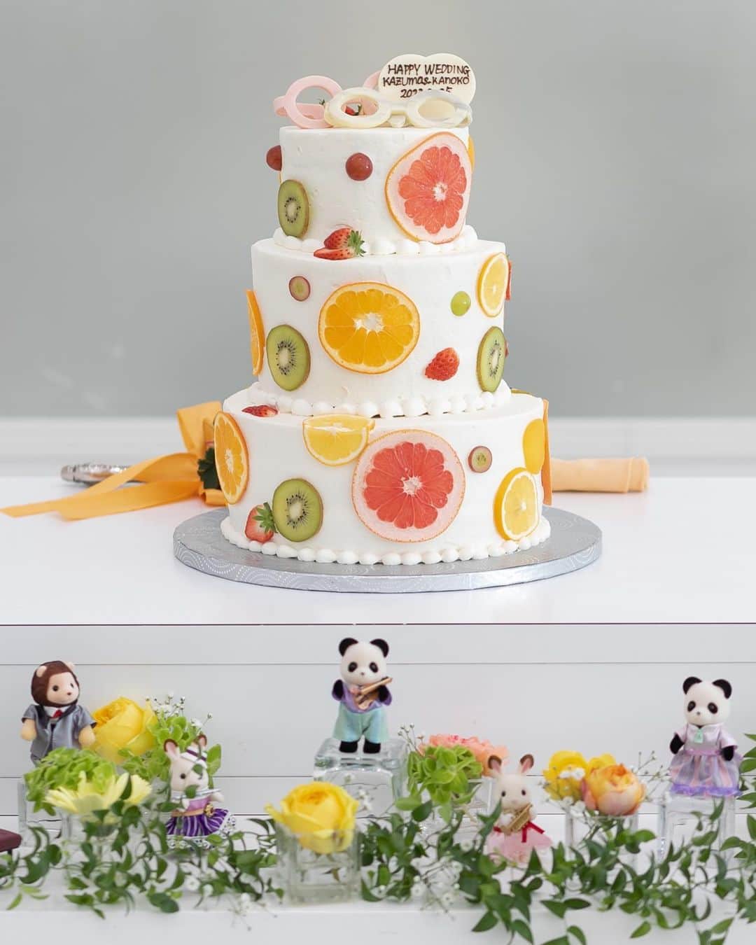 ラ セーヌ マリアージュ四日市さんのインスタグラム写真 - (ラ セーヌ マリアージュ四日市Instagram)「・ 可愛いすぎる！ ウェディングケーキとケーキ装花をご紹介！！  おふたりにはカラフルポップな #フルーツ断面ケーキ をお選びいただきました🍊🌿  フルーツ断面ケーキとは❔ 様々な種類のフルーツをうすくスライスして、ケーキ本体に貼ってデコレーションしたケーキのこと🤍  鮮やかなフルーツが主役になるので、お写真映えもバッチリ✨ ケーキ1番上には、おふたりのチャームポイント！ メガネのオーナメントも飾られておりますよ〜！！  明るいおふたりにピッタリのケーキでございます◎  画像2枚目のケーキ周りの装飾にもご注目❕ 新婦様の大切な大切なシルバニアファミリーの仲間たちが大活躍🐰 ケーキ周りを可愛いくおもてなし💭  おふたりのお好きなものを取り込んでオリジナルのウェディングケーキを作成出来ます。 プランナーにお気軽にご相談くださいませ🫧  _____________________________  #ラセーヌマリアージュ四日市 #マリアージュウェディング   #三重平安閣 #三重平安閣グループ #平安閣#披露宴#結婚式 #チャペル#ウエディングドレス #photo#chapel #wedding#bridal #2023秋婚#2023冬婚 #2024春婚#2024夏婚#2024秋婚 #ブライダルフェア #海外wedding #フォト婚#ウエディングフォト#東海プレ花嫁 #プレ花嫁#四日市結婚式場#四日市結婚式場ならマリアージュ  #四日市フォトウェディング#四日市フォトスタジオ」6月30日 17時36分 - lascenemariage