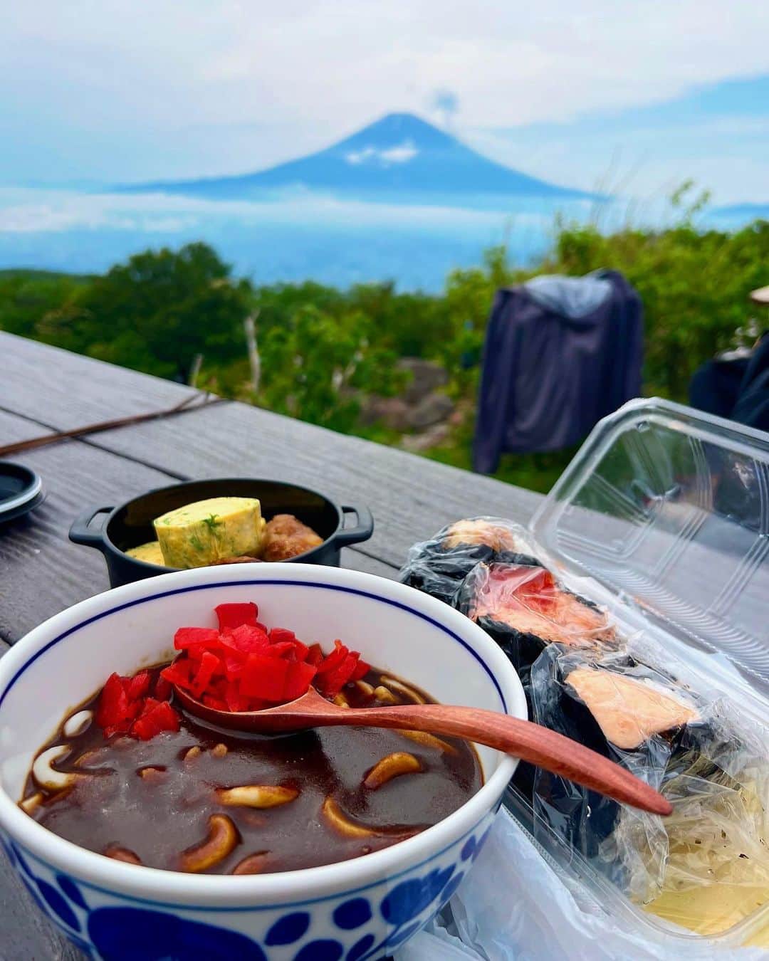 一双麻希 さんのインスタグラム写真 - (一双麻希 Instagram)「富士山バックに✨最高に贅沢な山ランチ😌🍙 金時山の頂上には #金太郎茶屋 があり、 お勧めを聞いたら『うちはカレーうどんだよ！』と教えてもらったので☻ 頼んでみたらスパイスしっかり効いててめちゃくちゃ美味しかった😆😆 茶屋でご飯を頼む予定じゃなかったので、 持ってきたおにぎりと、作ってきたおかずとで山盛りランチになってしまいました。😂(食べきれずw) 富士山を望みながら幸せいっぱいでいただきました😋  山登って消費したから今日は何でも食べていいんだー！て思って気にせず食べちゃう時間が好き。笑 結局消費分よりプラスな場合が多いけど。😇  #金時山 #山ご飯 #山飯    #箱根 #登山初心者 #百名山 #低山 #低山ハイク #富士山が見える場所 #絶景 #山女 #山ガール #山好き #登山女子 #山好き #登山 #山好きな人と繋がりたい #アウトドア好き #日本の絶景 #アウトドア女子 #ハイキング #富士山 #登山ファッション #登山コーデ #peakperformance #newera #japanview #mtfuji #hiking #いっそうまき山記録」6月30日 18時23分 - isso_maki315