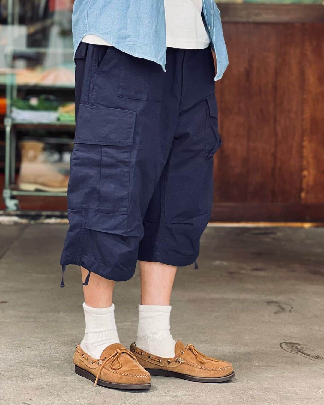 BEAMS+さんのインスタグラム写真 - (BEAMS+Instagram)「・ BEAMS PLUS STYLING.  < ENGINEERED GARMENTS> ×＜BEAMS PLUS＞ BDU 3/4 Shorts NAVY RIP-STOP  The "Jungle Fatigue Pants" were custom-designed by "ENGINEERED GARMENTS" designer Daiki Suzuki and sold out in the blink of an eye during the 22SS season. The pocket work and 3/4 length are reminiscent of the story of that time. This season, the pants are available in three materials: olive cotton poplin, ripstop navy, and military denim, which was very popular in the previous season.  ------------------------------------- . 22SSシーズンに瞬く間に完売を博した〈ENGINEERED GARMENTS〉デザイナー鈴木大器氏によってカスタムデザインされた『ジャングルファティーグパンツ』。 当時のストーリーを彷彿とさせるポケットワークと3/4レングスが魅力。 今シーズンは、コットンポプリンを採用したオリーブ、リップストップのネイビーに加え、前回人気の高かったミリタリーデニムの計3素材を展開。  #beams #beamsplus #beamsplusharajuku  #harajuku #mensfashion #mensstyle #stylepoln #menswear #engineeredgarments #bdu #shorts」6月30日 20時31分 - beams_plus_harajuku