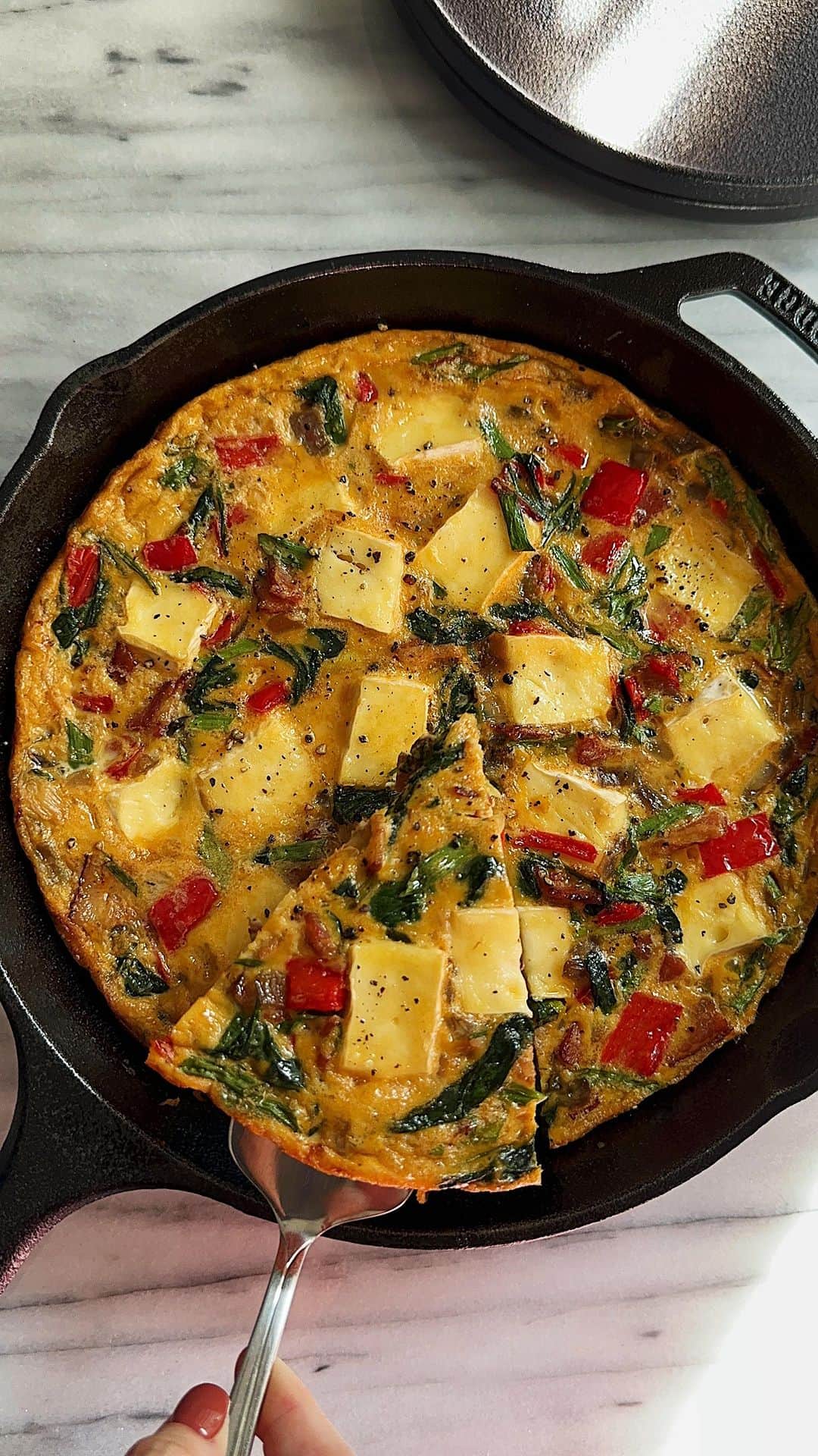 Samantha Leeのインスタグラム：「Eggcellent Frittata with Bacon, Spinach, and Brie! Smokey bacon, gooey Brie, vibrant spinach, and sweet red pepper that’ll leave you craving seconds.  #leesamantha #frittata   Recipe: Olive oil 8 slices of smoked streaky bacon, chopped  1 red onion, diced Red pepper, diced 3 spring onions, sliced diagonally  Handful of spinach 1 Brie  8 large eggs, beaten  4 tbsp grated Parmesan cheese  Salt and black pepper  1. Preheat the oven to 180°C. 2. In a large mixing bowl whisk together eggs, Parmesan, spring onions and season generously with pepper. Whisk your egg mixture well. Set aside.  3. Heat some olive oil in a 10-inch ovenproof frying pan and fry the bacon for 3-4 minutes. Add the red onions and sweat for a few minutes. Add the red pepper and continue to cook until the bacon is golden brown. Add the spring onions(white) and sweat for 3-4 minutes until everything is tender. Stir in spinach, roughly mixing it through the vegetables. Season with salt.  4. Now place the cooked bacon and vegetable mixture into the bowl with the egg mixture and whisk to combine.  5. Warm the pan over medium heat and drizzle some olive oil. Pour the mixture back into it. Cut one Brie into chunks and scatter on top. As the omelette begins to bubble and set around the edges, grate some Parmesan on top and season with pepper.  6. Place the pan in the hot oven for around 10 minutes until cooked through and golden on top.  Serve warm.」