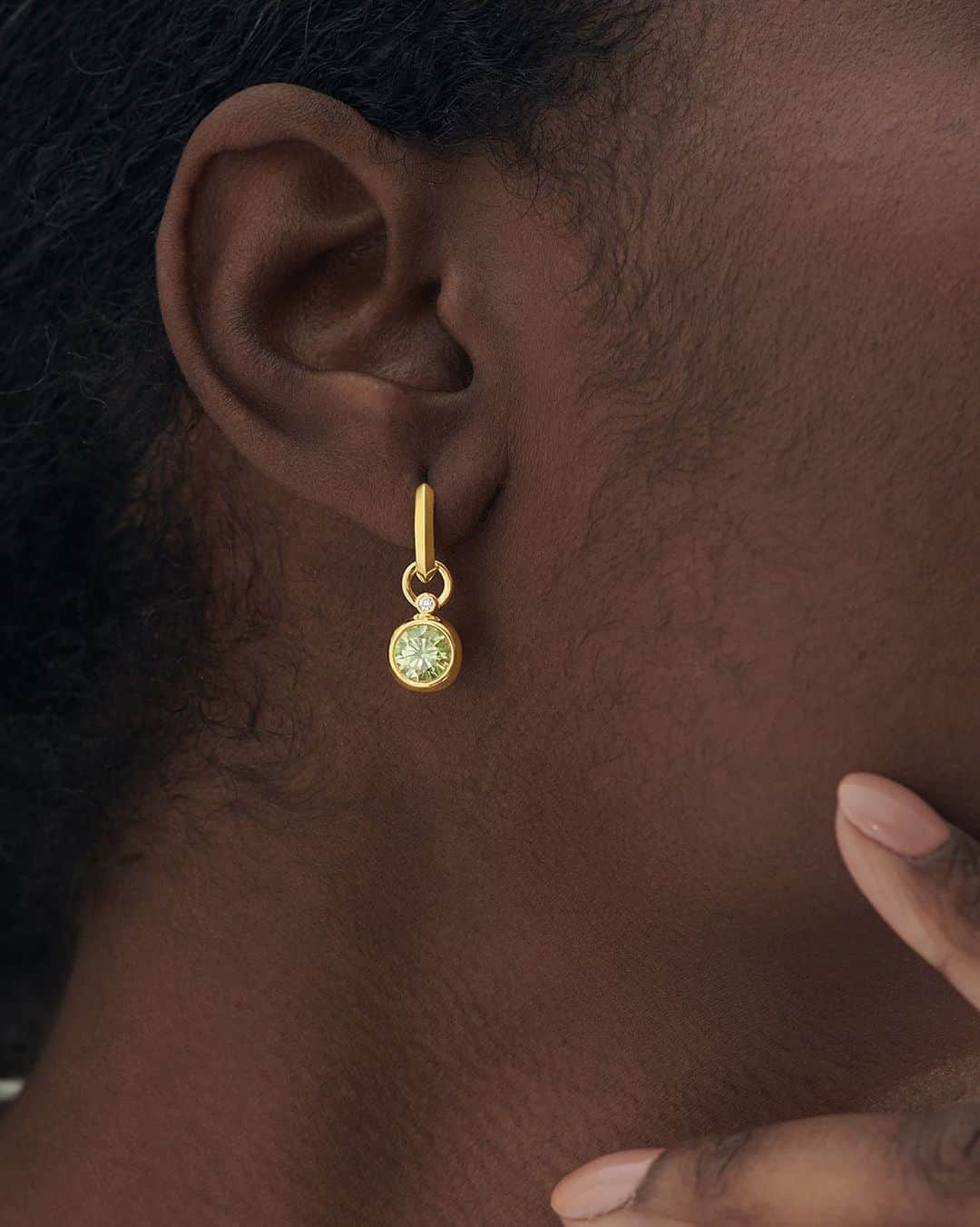 モバードのインスタグラム：「Versatile and essential. Our gemstone drop huggies have a removable luminous round green peridot charm accented by a petite diamond. Shop all earrings on Movado.com now.」