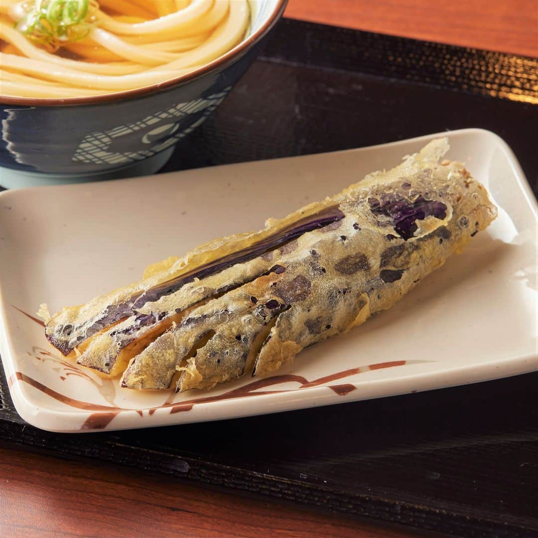 丸亀製麺のインスタグラム：「食べてみたい期間限定天ぷらをコメントで教えてください👀  今月も旬の味わいが楽しめる季節限定天ぷらが登場！ ラインナップはこちら👇  🥢そのままサクッ、だしにつけてジュワッと味わいたい #長なす天 🥢味も見た目も大満足！見つけたら必食の #ジャンボカニカマ天 🥢ふっくらした身に旨みがぎゅっと詰まった #いわし天  この機会にぜひお試しください😋  ※一部取扱のない店舗がございます。 ※長なす天は、北海道などの一部店舗ではなす天となります。  #丸亀製麺 #丸亀うどん #udon #麺 #うどん #天ぷら」
