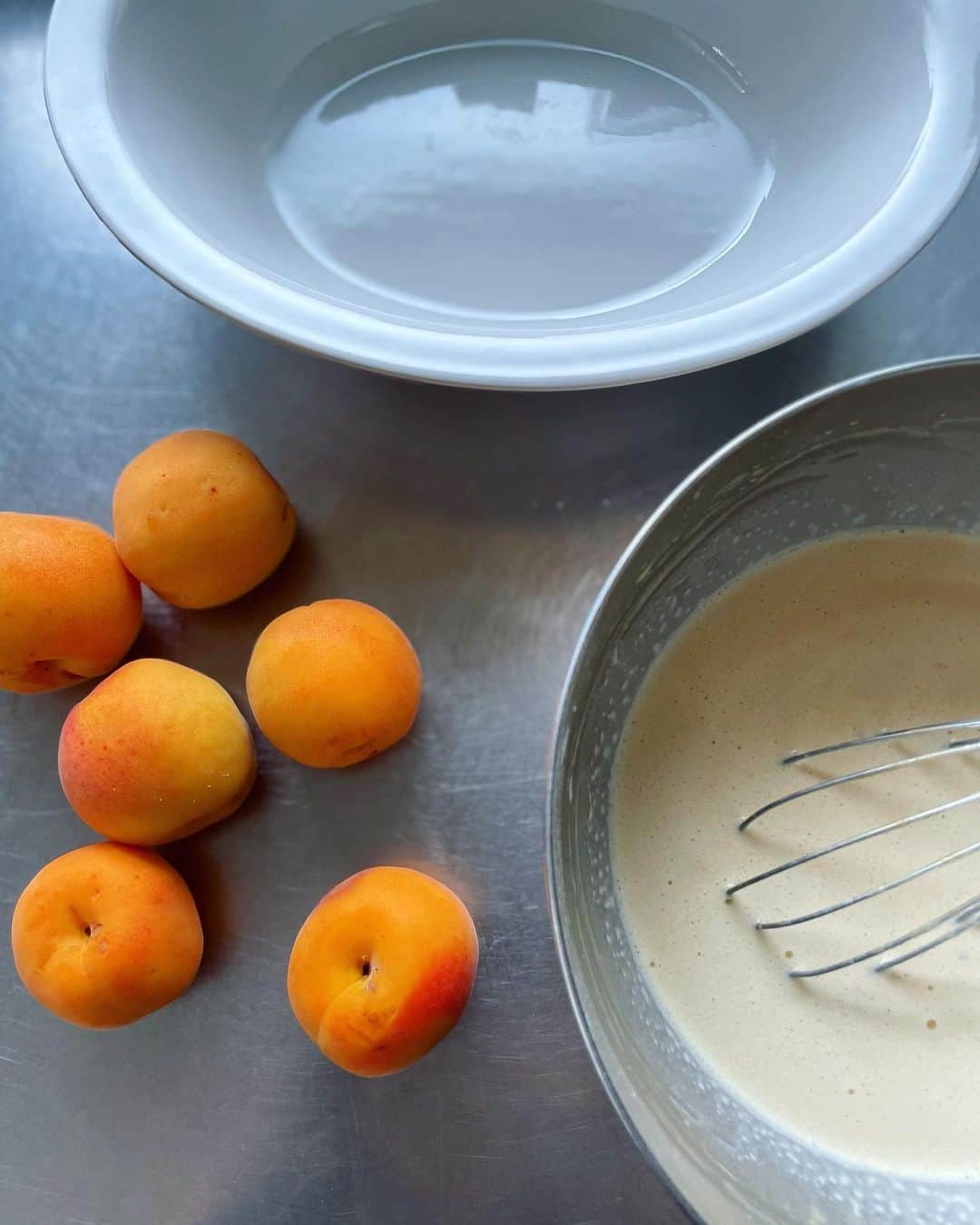 内田真美さんのインスタグラム写真 - (内田真美Instagram)「. 週末のおやつにClafoutis aux abricots. ほんの一瞬しか出回らない生食のアプリコットをクラフティに。 カスタード味、火の通った果実も好物というクラフティ好きの家族の為に作ったが、プラム類の花弁のような華やかな香りに熟れた果実の芳香とバニラが合わさり、卵とミルクの交わったところを口に入れた瞬間の素晴らしさよ。 わが家は、粉類少なめで湯煎焼きにし冷やして頂戴する。果実と焼きカスタードのような素朴さが日常に丁度良いのだが、他の菓子に比べて季節の果実を思う存分焼き込めるのも良い菓子だと思う。 たっぷりと作り冷蔵庫にどんと鎮座しており、好きな時に好きなだけ頂戴できるのもいいのだ。 本家リムーザンのようにチェリーのクラフティも焼きたい。  #私的甘もの放談」7月1日 18時36分 - _mamiuchida_