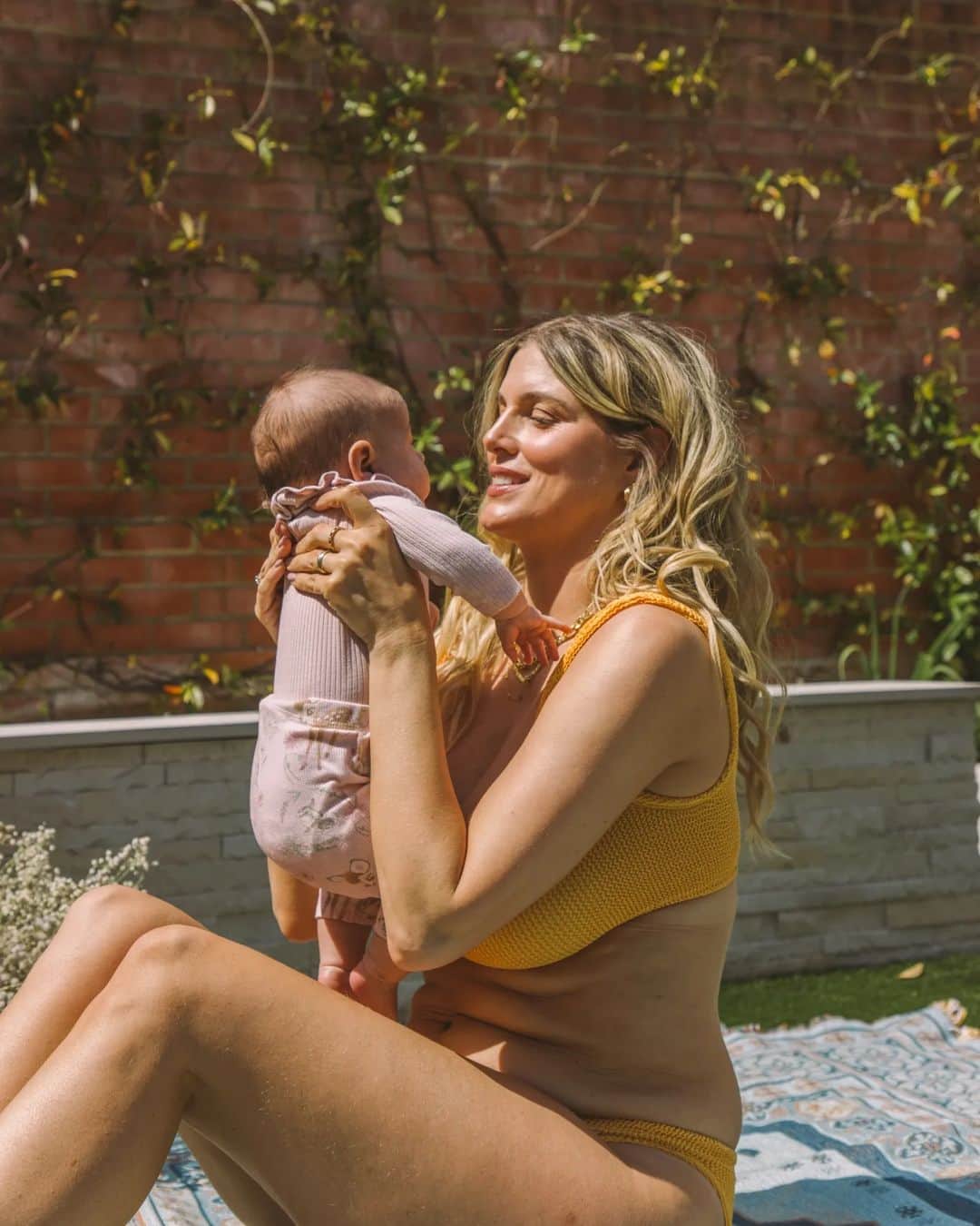 Ashley Jamesさんのインスタグラム写真 - (Ashley JamesInstagram)「The sun came out unexpectedly this afternoon so I hunted out a bikini and enjoyed some time in the garden.  I read this week that a new mum in the pubkic eye vowed not to wear a bikini after having a baby until she had her body back. It made me feel really sad for her and for all of us that that's how we're made to feel in society.  Our body has done this epic and miraculous thing that is literally essential for humanity continuing and yet we're made to feel ashamed of it.   It’s funny because in terms of how society views bodies, my body isn’t like it was before. Of course it isn’t, I’ve birthed two babies in the last 2 1/2 years. But I’m a lot more confident than I ever was. 💪  I used to think if I was just a bit thinner, or when I had hair removal or when I had abs or when I had a tan - then I’d be confident. It was always WHEN. And I never achieved when.   I remember going on holiday in my 20s and feeling like my body wasn’t good enough to wear a bikini.. I’d worry about shaving marks and ingrown hairs. And cellulite. And the stretch marks. I’d worry about the hair on my belly. About the roll on my belly (spoiler alert: It was skin. A skin fold.) I’d sit amongst a group of friends and look at their bodies and think how lucky they were as I sat with a towel covering myself.   But nobody was zooming in on my body like I was.   I didn’t eat pasta for almost a decade. I mean, I bloody love pasta.   I used to google how to be confident. I felt like I’d never find love until I was perfect.   I look at that same body from my 20s now and think how amazing I looked. How I wish I knew it. But also, how it didn’t define me. Ironically I was also a lingerie model back then.   Where did I learn to hate myself so much? From comments made around me by adults when I was young, from descriptions of women's bodies in magazines ...   Mostly I’ve learned that I don’t need to love my body to wear clothes. I’m neutral about it - I am grateful for it for everything it allows me to do. i don’t care what people think of it. I’m not an object.  And if I had my old body, then I wouldn’t have my babies. So I think that is reason enough to appreciate it and to wear the bikini. 🌞🫶💛」7月2日 5時10分 - ashleylouisejames