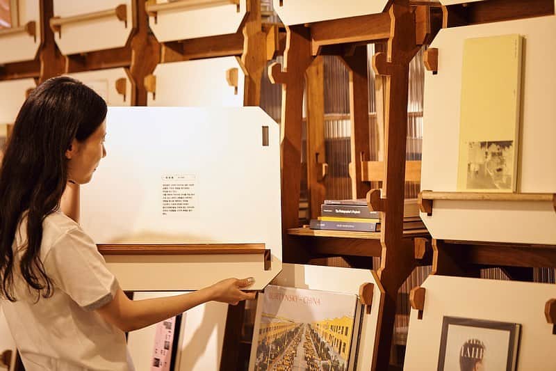 前田エマさんのインスタグラム写真 - (前田エマInstagram)「Hanako連載「前田エマの秘密の韓国」 今回は仁川にある『写真の図書館』を訪ねました📷📚 ここにはとても不思議な本棚があるんです。秘密の扉のような白い棚を開けると、そこには写真家たちが影響を受けた作家や作品たちと出会える仕組みが！！わくわくする場所です。  私はこの図書館(無料！)に何度か訪れたことがあるのですが、先日とても素敵なワークショップを見学させて頂きました。  それは「見えない写真に声を与える」というもの。 大学で写真を専攻されていた俳優のコン・ソンハさん @kongseongha が講師。その内容は、記事に少し書きましたので、是非ウェブサイトをご覧ください。素晴らしい時間をありがとうございました🙏🏻  仁川は空港がある街として有名ですが、とても文化的な面白い街です。 是非、行ってみてください。  @hanako_magazine  #lbdfoto Photo @mio_matsuzawa #秘密の韓国  https://hanako.tokyo/learn/383556/#heading-1」7月2日 11時37分 - emma_maeda