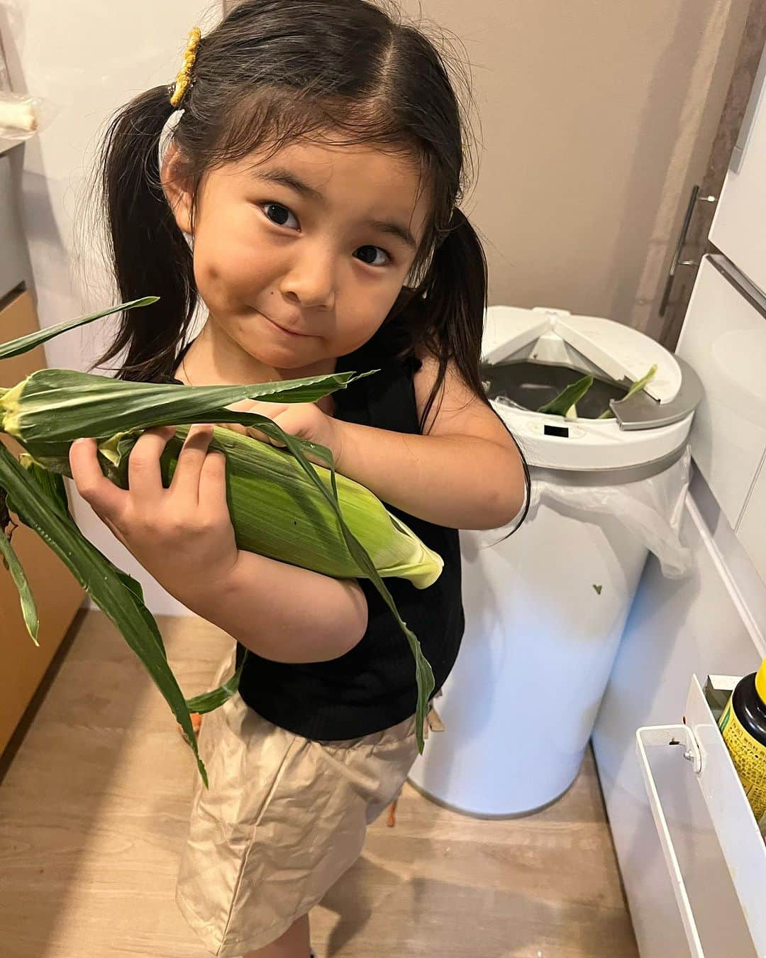 クロのインスタグラム：「お手伝い大好き🌽🌽🌽 えくぼかんわいっ😳  ほんっぅおペラッペラ話すのに （なんかほんと小言見たいの言ってて、おもろいし、うっさいw）  まだまだ「とうもろこし」を手にもっととうもろこしが大きく見えるのかんわいっ♥️♥️♥️  👧🏽:「お手伝いがしたいっ！」 👧🏽:「ママの髪の毛可愛くするね〜」 👧🏽:「お風呂出たらアイス食べながら耳をすませばみよっか」  自分の手を進められる範囲の注意力の中でのお手伝いをお願いするの、ホント大変よね。 とうもろこしの皮をむく、ピーマンの種とり、キャベツちぎる… 昨日はタコと、ポークピッツ切らせちゃった。 あんま見てなかったのに、でもできてた、手切らなくて良かった…💨 小さな女の子との二人の生活は二人のペースでゆるゆる楽しんでおります✊🏽♥️♥️♥️ 娘の優しさに甘えてばかりですが、引き続き自分るしく楽しむぞ〜！！！  #クロ #母娘 #ちびクロdiary #4y11m」