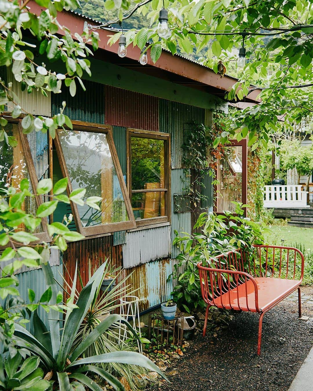ZERO-CUBE+FUNさんのインスタグラム写真 - (ZERO-CUBE+FUNInstagram)「. 東京から湘南エリアの稲村ヶ崎に引っ越したことを機に、自宅の庭に理想のガレージを建てた池田紀行さん。  @ikedanoriyuki  自分の“好き”を形にした建物は、古びたトタンと多様な植物に覆われた趣のある佇まい。趣味と仕事が同居する、唯一無二のガレージライフとは。  記事は @lifelabel_official プロフィールから。  #lifelabelmagazine #houseisentertainment #Lmag  #一戸建て #芝生の庭 #ジャングルハウス #ガレージ #ガレージハウス #大人の秘密基地 #トタン #サーファーズハウス #カリフォルニアスタイル #ワーゲンバス #湘南ライフ #湘南スタイル #稲村ヶ崎 #鎌倉 #ワークスペース #architecture #homedesign #homestyling #diy #lifelabel #ライフレーベル #趣味を楽しむ #ライフスタイル #暮らし #暮らしを楽しむ #暮らしのアイディア #家づくり」7月3日 18時16分 - lifelabel_official