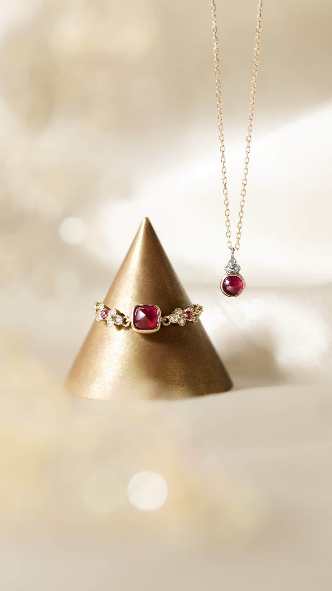 AbHerї〈アベリ〉のインスタグラム：「【今月のおすすめ “Ruby Jewelry” 】7月の誕生石「ルビー」をあしらったチェーンリングとネックレスが入荷いたしました。   チェーンリングは、「砂糖のかたまり」を意味するとても珍しいシュガーローフカットのルビーがトップに留められています。立体的で艶やかに煌めく上質なルビーを引き立てるように、精細なミルグレインを施した小花の装飾がサイドを飾ります。   ネックレスは、ふっくらと愛らしいラウンドのカボションカットのルビーに、プラチナとダイヤモンドの小花を添えたシンプルなデザイン。胸元をさりげなく彩り、普段使いしやすいワンポイントのネックレスです。   アベリでも人気のルビージュエリー。どちらも数量限定品になりますので、どうぞお早めに直営店舗にてご覧くださいませ。 　 　 　 ■Ruby Ring Design №：1413H Details：K18CH, Ruby, Diamond ￥495,000 (tax included)   ■Ruby Necklace Design №：1499A Details：K18CH, PT, Ruby, Diamond ￥198,000 (tax included) 　 　 　 ▶数量限定品になります。在庫状況については直営店舗へお問合せくださいませ。   ▶︎オフィシャルサイト、オンラインショップは @abheri_official のリンク先abheri.comよりご覧いただけます。       #abheri #abherï #アベリ #ジュエリー #ファインジュエリー #リング #チェーンリング #アベリチェーンリング #指輪 #ルビー #ルビーリング #ネックレス #ルビーネックレス　#カラーストーン #カラーストーンジュエリー #カラーストーンリング #ジュエリー好き #ご褒美ジュエリー #お守りジュエリー #記念日ジュエリー #7月の誕生石 #誕生石リング #宝石 #宝石好き #色石リング #シュガーローフ #jewelry #rubyring #rubynecklace #sugarloafcut」