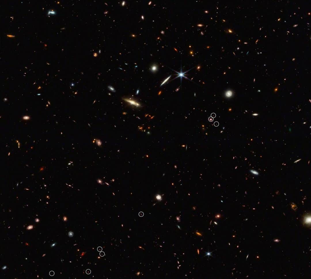 NASAさんのインスタグラム写真 - (NASAInstagram)「🎇 They’re not quite fireworks, but stars and galaxies in @NASAWebb’s image of an early strand of the “cosmic web” sparkle in the sky. Ten galaxies in this image existed just 830 million years after the big bang. Talk about historic!  Happy #FourthOfJuly!  Image Description: A black field speckled with a variety of galaxies of numerous shapes and sizes. The galaxies are white, yellow, blue and red. Red is the predominant galaxy color in the field, indicating very distant galaxies. Eight small white circles mark the position of 10 galaxies (two circles contain more than one galaxy). The 10 galaxies are arranged in a diagonal, thread-like line from the bottom left to the top right. Most of the white circles are separated. However, there is a pair of circles grouped together on the bottom left, as well as a cluster of three circles on the right side of the image. A quasar called J0305-3150 appears in the middle of that right cluster. Within the quasar’s circle, there are strong red diffraction spikes radiating out from a white core. Galaxies in the other circles are seen only as red specks.  #Space #NASA #JWST #Webb #UnfoldTheUniverse #July4 #Fireworks」7月4日 23時20分 - nasagoddard