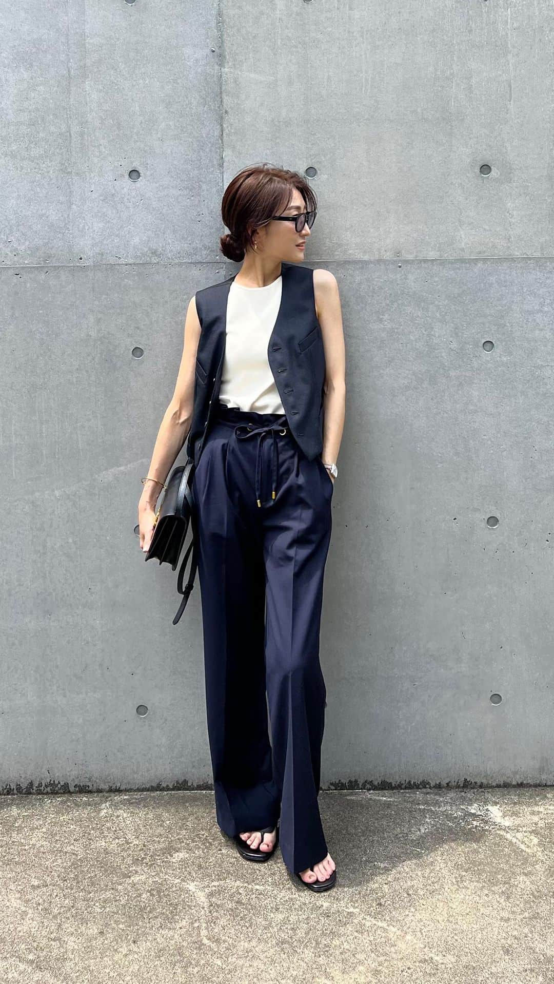 金子麻貴のインスタグラム：「真夏のベストコーデ。  このベストに合わせたかったドロストデザインパンツ。 サラッとしてて暑い日も履きやすい✨  ベストでマニッシュ感強くなるのでペタンコサンダルを合わせて足元はラフな感じに。パンツはもうすぐです💓  tops @cosstores_jp  vest @madisonblue_official  bottom @re_gleam  sandal @hermes   #fashion#reels#reelsinstagram#regleam#cos#madisonblue#hermes#burberry#ネイビーコーデ#ベストコーデ#パンツコーデ#シンプルコーデ#コーディネート#夏コーデ」
