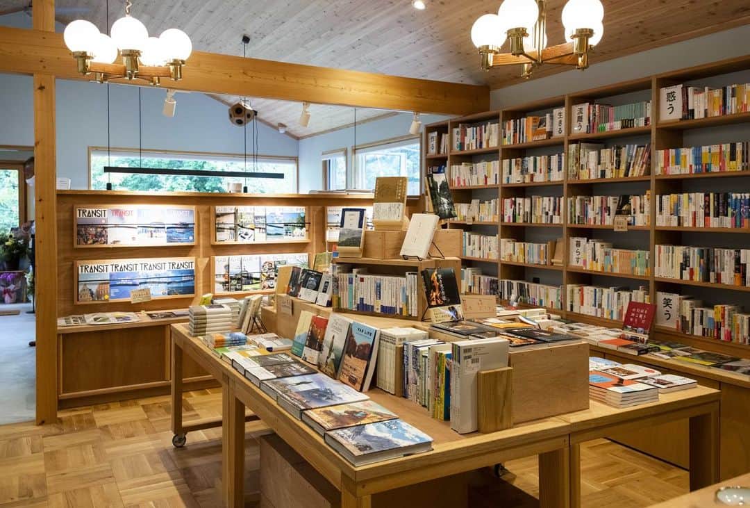 toolbox(ツールボックス)さんのインスタグラム写真 - (toolbox(ツールボックス)Instagram)「普段は手が伸びなかったジャンルが気になったり、難しそうと、読むのを躊躇していた一冊に手が伸びたり。本を選ぶ時、その場の雰囲気に後押しされることがあります。  緑に囲まれた森の本屋さん「のほほん」。「山暮らしの本屋」がコンセプトのお店で、併設されたカフェスペースと共に、森の中でじっくり読書に没入できる時間を提供しています。  お店の中は淡いブルーの塗装壁で、外の緑を鮮やかに見せてくれます。  カフェカウンターは、リブパネルやタイルで装飾。縦貼りにした『フロストタイル』。よく見かける横並びの貼り方と比べて、伸びやかさが強調されているように感じます。  本のスペースは、床を『スクールパーケット』に。色とりどりの本の背表紙と相まって、ちょっとワクワクするような、楽しい気分になってしまうのは私だけでしょうか。  お近くにお越しの際は、本と出会いにぜひ訪れてみてください。  @nohohonbooks  #toolbox #r_toolbox #家づくり #インテリア #interior #ツールボックス #店舗 #デスク #テーブル #本棚 #のほほんbooksandcoffee #本屋 #カフェ #ブックカフェ #スクールパーケット #木製室内窓 #フロストタイル」7月4日 21時00分 - r_toolbox
