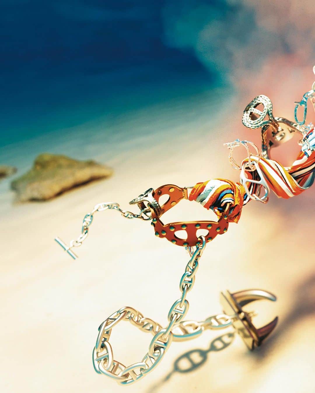 エルメスのインスタグラム：「Chain reaction 🔗⚓ Dive beneath crystal blue waters and discover the Chaine d’ancre motif. A house signature since 1938, seen today in Le Monde d'Hermès.​  The story behind: In 1937, Robert Dumas watched boats as he strolled along the Normandy coast. The anchor chains that held them in place caught his eye and inspired the shape of the iconic Chaine d'ancre motif. This exemplifies the "intelligence of the eye" and the harmonious balance between practicality and beauty that is quintessential to the Hermès philosophy. It was in 1938 when the Maison ventured into uncharted waters and crafted the first silver Chaine d'ancre bracelet. Since then, this motif has been an endless source of inspiration, undergoing a plethora of interpretations, utilizing various materials and shapes, all while preserving its essence.​  3D illustration by @berenicegolmann​  #DiveIn​ #ChaineDAncre​ #LeMondeDHermes​ #Hermes​」
