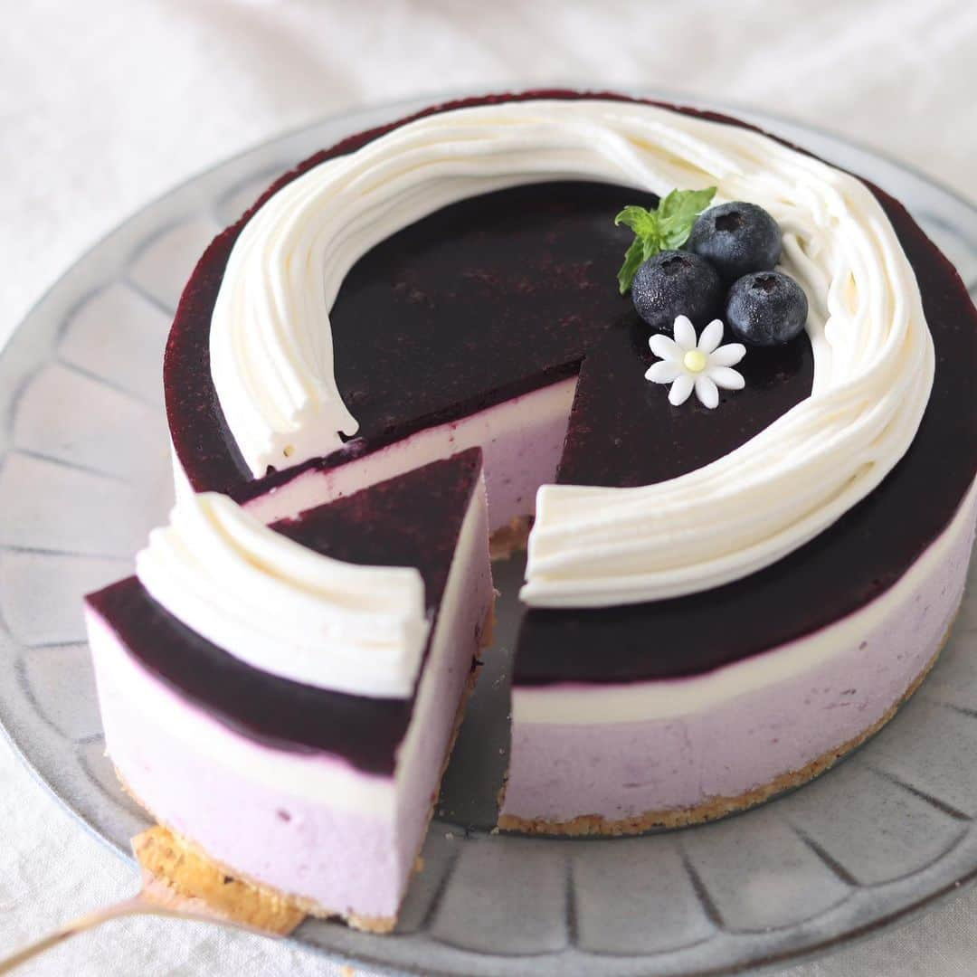 HidaMari Cookingさんのインスタグラム写真 - (HidaMari CookingInstagram)「No bake blueberry cheesecake🦋  焼かないブルーベリーのレアチーズケーキ🫐 最近暑いのでへたってます😂笑  ▷材料（φ15cm）： ■ブルーベリーレアチーズ クッキー　７０ｇ 無塩バター　２０ｇ  クリームチーズ　２００ｇ 砂糖　３０ｇ ゼラチン　５ｇ お湯　２０ｇ 生クリーム　１３０ｍｌ 砂糖　１０ｇ レモン汁　５ｍｌ ブルーベリーピュレ　４０ｇ  ■ブルーベリーピュレ ブルーベリー　１００ｇ 砂糖　３０ｇ レモン汁　１０ml ゼラチン　３ｇ  ■トッピング 生クリーム　７０ｍｌ 砂糖　５ｇ レモン汁　５ｍｌ  ▷作り方： １．クッキーを細かく砕き、溶かした無塩バターを加えてなじませる。型に敷き詰める。 ２．ブルーベリーピュレを作る。鍋に材料を入れて火にかけ、果肉が潰れるまで煮る。 ３．ブルーベリーピュレを濾して、氷水でふやかしておいた板ゼラチンを加えて溶かす。 ４．チーズケーキを作る。クリームチーズに砂糖を加えてなめらかになるまで混ぜる。 ５．氷水でふやかしておいたゼラチンをお湯に加えて溶かす。④に加えて混ぜる。 ６．生クリーム130mlに砂糖を加え、緩めに泡立てて加え混ぜる。レモン汁も加えて混ぜる。 ７．出来上がったレアチーズケーキの内120gを取り分けて、ラップをして室温に置いておく。 ８．ブルーベリーピュレを40g加えて混ぜる。①の型に流し入れ、冷凍庫で30分表面が固まるまで冷やす。 ９．⑦を流し入れ、冷凍庫で30分冷やす。 １０．ブルーベリーピュレをすべて流し入れ、冷蔵庫で一晩冷やす。 １０．生クリーム70mlに砂糖、レモン汁を入れて絞れる固さになるまで泡立てる。固まったレアチーズケーキにデコレーションして完成です。  #homemade #easy #recipe #tutorial #baking #foodstyling #foodporn #food #foodphotography #foodpics #foodgasm #tasty #dessert #inspiration  #おうちカフェ #お菓子作り #手作りケーキ #ケーキ作り好きな人と繋がりたい #手作りお菓子 #cake #sweets #homecafe #homemakecake #instacake #instafood #cakestagram #cakelover #foodie #hidamaricooking」7月7日 20時00分 - hidamaricooking