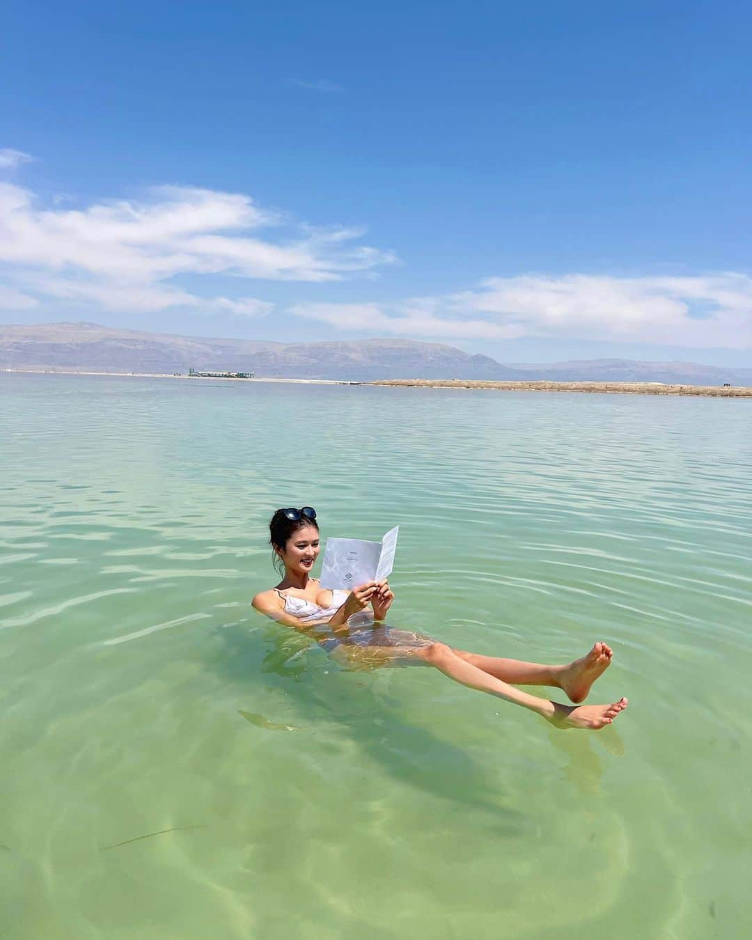 東野佑美のインスタグラム：「📍Dead Sea, Israel 死海〜！🇮🇱 ほんとにポンって浮くの。不思議🥹🩵  本を読むやつもやってみました🤣 ずーっとぷかぷか浮いてた🧚🏻‍♀️🫧  浮いちゃうから底にあるソルトを掴むのは 至難の業なんだけど プロは足の指を使ってひょいひょいっと いとも簡単に！！🫨 両手いっぱいにくれたよ❄️コロコロ可愛い🫶  #死海 #イスラエル #中東 #海外旅行 #deadsea」