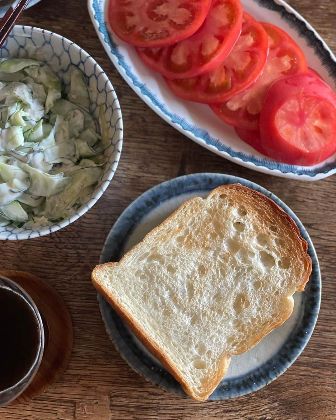 冨田ただすけのインスタグラム：「食器棚からあふれそうなほど器が多くなっても、「もう買わないぞ」と強く何度も思っても、Instagram見てたら器が欲しくなります☺️  今日は最近のお気に入りの器で昼ごはん。夏野菜たっぷりのオープンサンドにしました。  塩もみしたキュウリにマヨ&こしょうを合わせ、スライストマトも用意して。（トマトは @sakanotochu さんの定期便から、パンは名古屋の @suripu_insta さん）  オーバル皿はベルギーの古いアンティーク。パンをのっけた平皿はヤフオクで買った古いもので、作者は不明ですが河井寛次郎に師事した河井武一さんか河井久さんのものかも（詳しくないから全然わかんないのですがヤフオクの情報からすると）とにかく、ぽってりとして雰囲気の良い平皿です🙌  白ごはん.comストアではじめて器を企画して作ってみたのが2年前くらい。それも毎日のように愛用してますが、こういう食卓が楽しくなる器をまた企画してみようと思います〜。  #白ごはんドットコム #オープンサンド #アンティーク #骨董 #器 #器好き #冨田ただすけ #夏野菜 #坂ノ途中 #坂ノ途中のお野菜」