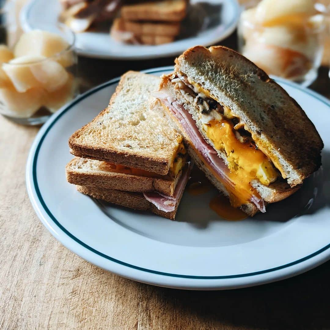 tamiのインスタグラム：「* #朝食 *  普段から好きなライ麦トーストに サンドイッチ用が出たので早速🥪  この薄さがいいわ〜♡  パン→チーズ→ハム →パン→目玉焼き→マッシュルームガーリックバター炒め →スパイシーオーロラソース→チーズ→パン  3枚使ってるけど余裕で食べれちゃう。 個人的にはトーストしてサンドするのがオススメ🤗  @takaki_bakery_official  * #休日の朝  #朝ごはん#モーニング#パン #タカキベーカリー#ライ麦トースト #サンドイッチ#ホットサンド #休日#食事#暮らし#食事の記録」