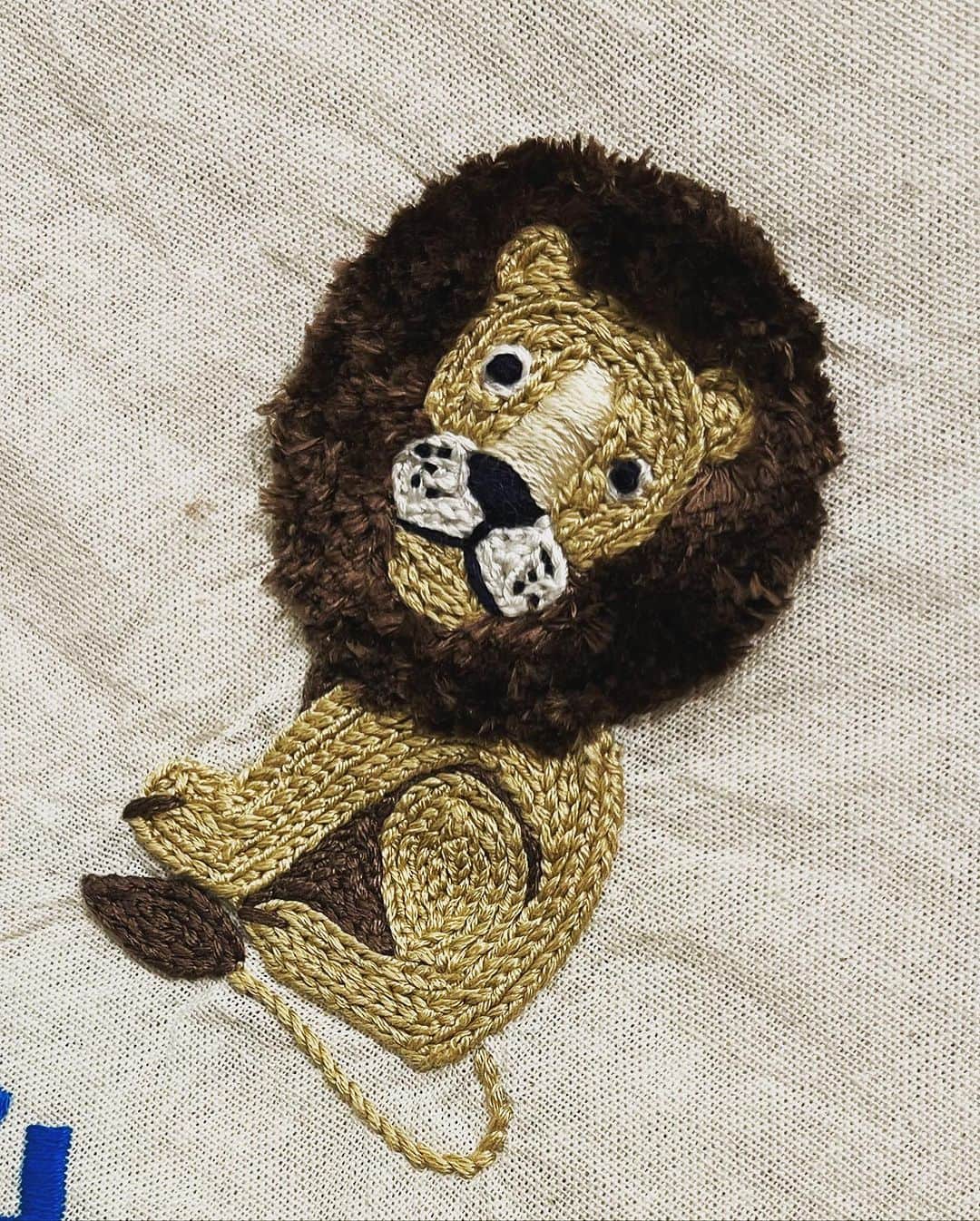 肘井美佳のインスタグラム：「Embroidered lion! A cat has been just started.  いつまでもじゃもじゃにしてるんだ！？  もじゃもじゃ頭をサッパリさせてふわふわになりました。立体刺繍かわいい…！  下にはオトートさんの名前をサテンステッチで刺繍しました。まだまだなのですが、始めた頃よりもちょっと上達してて自分で感動しました涙   オトートさんの巾着をオネーサンが羨ましそうに見ていたので、無地のワンピースにネコをつけてみようかと。可愛くできるといいな〜  #embroidery #lion #刺繍 #スミルナステッチ #ターキーノットステッチ #猫は鬼のチェーンステッチ #樋口由美子の動物刺繍をアレンジ」