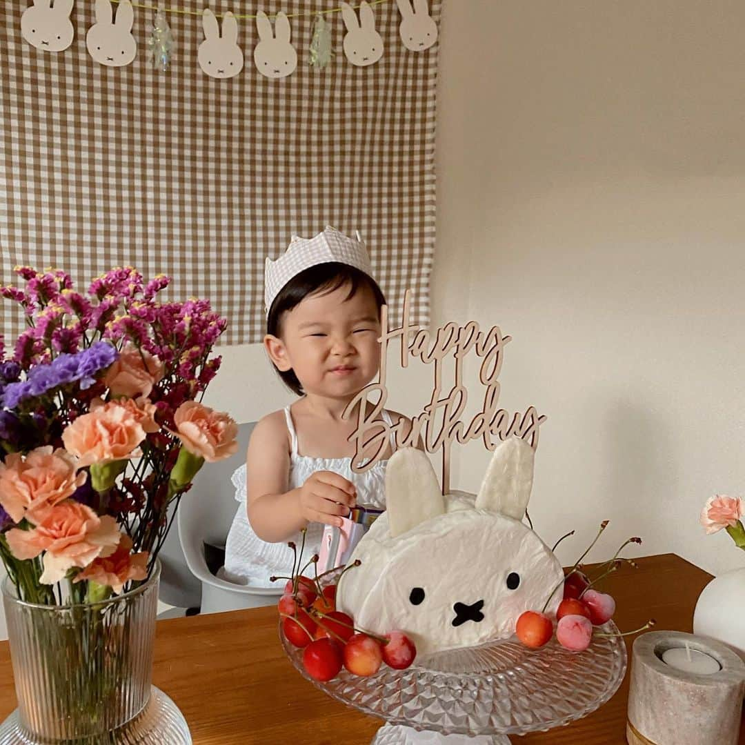 井村亜里香のインスタグラム：「Happy 2nd Birthday sui !🎂🍒  1日早いお祝いだったのだけど家族で ゆっくりお祝いしたかったので今日開催♡  suiと出会わせてくれて神様に感謝🕊  これからも楽しい時間をいっっぱい過ごしていこうね! BigLove♡  ミッフィーらぶなので スイーツ作りはド下手ですが、、、 インスタで見つけた手作りミッフィケーキに挑戦🫡  ✔︎前の日に100均で購入した黒チョコペンで目と口を仕込み。 ガサツなので携帯のスクショの上にクッキングシートを引いて書きました。  ✔︎外側はパルティノヨーグルトを使ったら 水切りしなくてもOKで楽ちんでした🥣◎  ✔︎耳の部分は赤ちゃんおせんべい。 サイズは微調整。  ✔︎中身は生クリームと好きなフルーツを 切って入れただけ。私はバナナにしました🍌  ✔︎最後にさくらんぼを飾りつけ。  お昼寝の時に作ったらまさかの冷蔵庫に入らず 冷凍したらさくらんぼがシャリシャリに🤣 ケーキの外側のヨーグルト部分は 固まってくれて結果オーライ。  数字の2のロウソクもネット購入したのに 今日に間に合わずポンコツすぎたけど、 すごく喜んでくれたので母満足🤭  ダイソーで見つけた ミッフィコラボのパーティグッズも 激カワでミッフィー皿とガーランドが大活躍🎉  ぜひどなたかのご参考になれば♡  #2ndbirthday#miffy#miffycafe  #miffylover#miffycollection  #2歳誕生日#ミッフィーケーキ #ミッフィーグッズ#2歳バースデー  #バースデーケーキ#ミッフィーコラボ #バースデーパーティー#2歳」