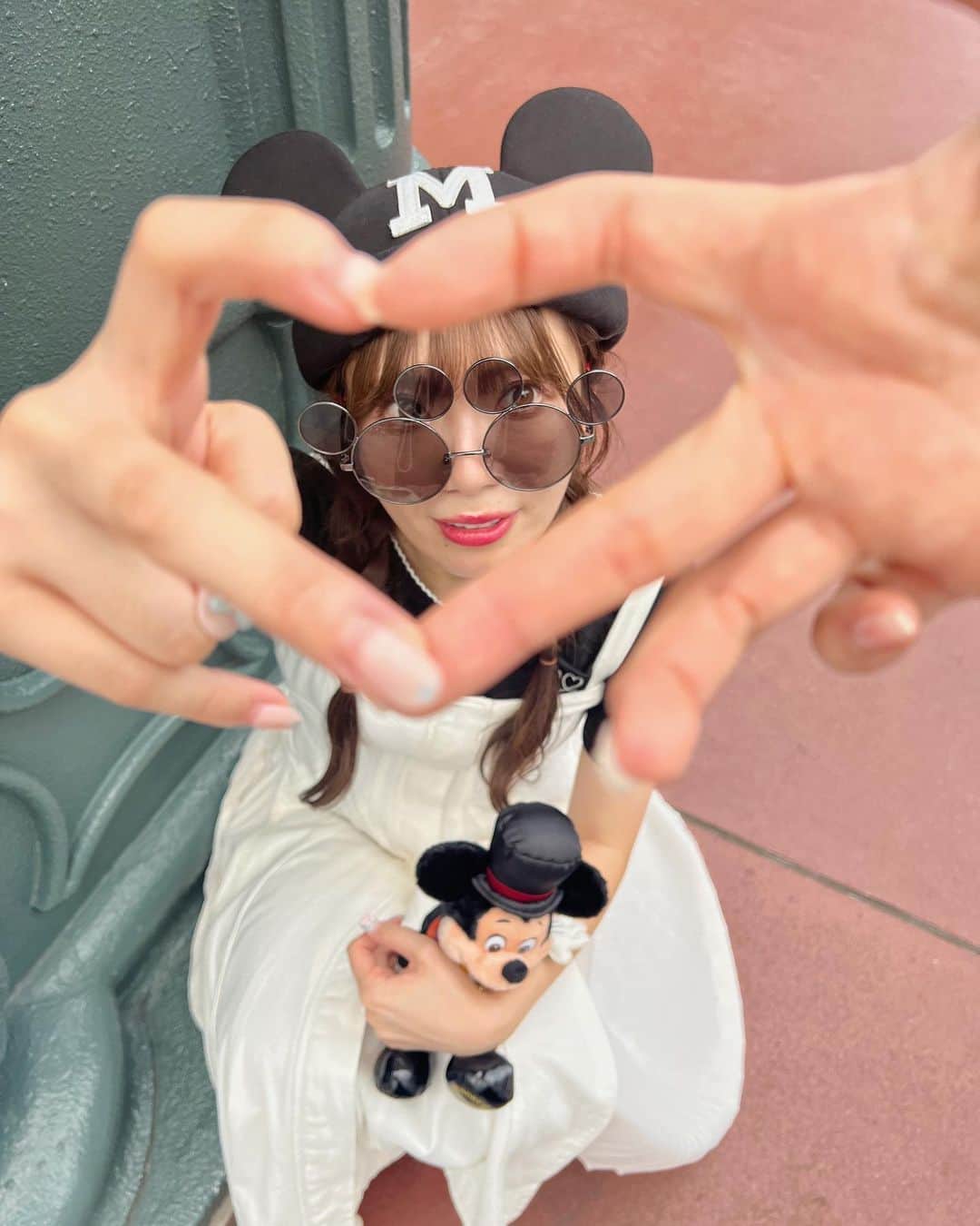 あいにゃんのインスタグラム：「流行りのハートポーズ🫶🏻💗💕  簡単にできると思ってやってみたら めちゃくちゃ難しい、、！😨💭  座って撮ってる方が多いなぁと思いながらも 普通に撮ろうとしたら2枚目のようになりました！笑🤣  なので、、、 ☑︎しっかり座って上から撮らないと ちょうどよくハートのなかに顔が入らない😨 ☑︎撮る人、撮られる人どちらも 指に力が入ってると可愛いハートにならない😨 ☑︎手にピントが合っちゃうので、顔にピントを固定しないとボケる😨  撮り方がわからない方は こちらに注意してやってみてね！🫶🏻  ちなみにお友達と2人でも撮れました🫶🏻💗💕 ただ1人よりも難易度高めで 何回も撮り直したので(4枚目) お時間がある時にぜひ！笑✨✨✨  #ハートポーズ#東京ディズニーランド#ディズニーランド#ディズニーコーデ#レトロミッキー#写真ポーズ#モノトーンコーデ #tokyodisneyland#tokyodisneyresort」