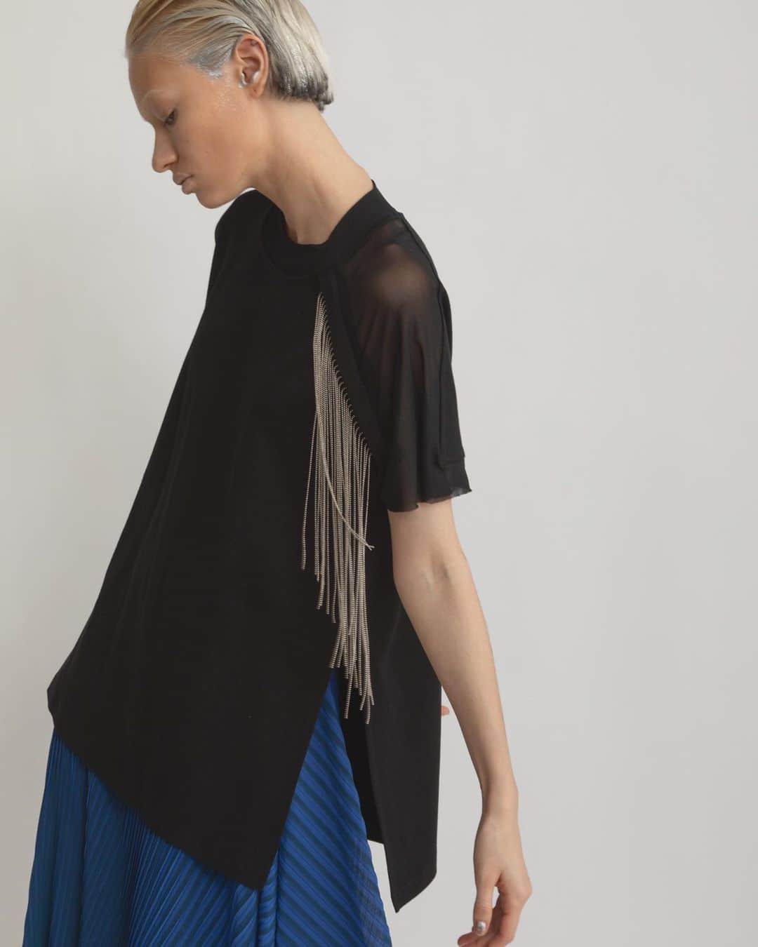 AULA AILAのインスタグラム：「【2023 HIGH SUMMER COLLECTION】  CHAIN FRINGE T-SHIRT COLOR BLACK SIZE 0 ¥16,500  ボールチェーンのフリンジ付きのTシャツ。 左胸から垂れるフリンジは、動くと揺れてアクセサリーが付いているようなデザイン。  フリンジはドットボタンで簡単に取り外し可能。  STRIPE PRINT PLEATS SKIRT COLOR BLUE×NAVY SIZE 0/1 ¥23,100  細いプリーツとストライププリントの加工を施したオリジナル生地をレイヤードしたスカートです。  内側スカートは左裾にスリットが開いたタイトラインで、表スカートは広げると長方形になるデザイン。 プリーツとストライプの縦柄効果が、造形的でシャープな印象のスカート。  ✔️AULA AILA OFFICIAL WEB STOREにて HIGH SUMMER COLLECTIONアイテム展開中！」