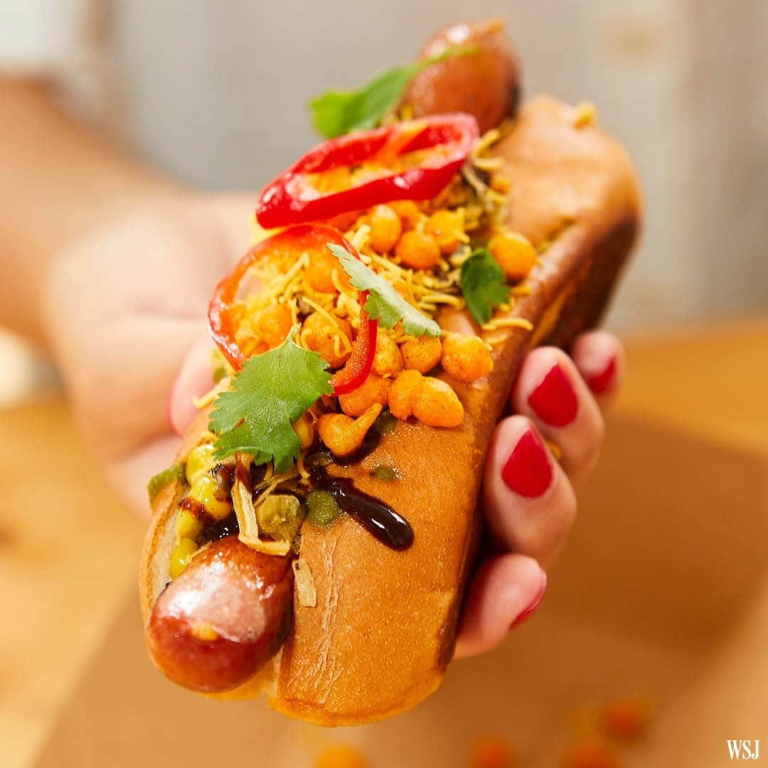 Wall Street Journalさんのインスタグラム写真 - (Wall Street JournalInstagram)「This summer’s hot dogs are fully loaded.⁠ ⁠ Americans buy more hotdogs in July—National Hot Dog Month—than any other month. Annually, U.S. grocery stores alone sell more than 900 million pounds of them, according to the National Hot Dog and Sausage Council.⁠ ⁠ Perhaps no food is more manifestly American than the hot dog, a vehicle for endless interpretation. And chefs around the country are going large with the garnishes.⁠ ⁠ The Chaat Dog, pictured here, is inspired by the Chicago-style dog, but swaps the classic “dragged through the garden” toppings with the South Asian snack chaat. The flavors reflect creator Pervaiz Shallwani’s Pakistani background, and the chaat varies depending on the season.⁠ ⁠ Shallwani layers on flavors and textures familiar to any South Asian kid: cilantro chutney, tamarind chutney, sev (chickpea-flour vermicelli), boondi (crunchy chickpea-flour balls), cilantro leaves, pickled chiles, fried onions and yet more spice.⁠ ⁠ At the link in our bio, find a guide to America’s extravagant and irresistible hot dogs, with recipes to recreate them at home.⁠ ⁠ 📷: @fmrphoto/@wsjphotos」7月10日 3時00分 - wsj