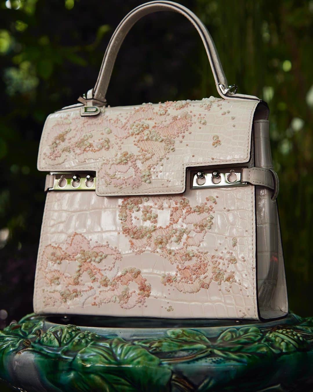 デルボーのインスタグラム：「Delvaux Haute Maroquinerie  June 3-5, Paris, 2023 “Pink Jasmine”  It takes 98 hours to create the abstract jasmine pattern on this one of a kind blush Tempête made up in silky pink alligator. Brussels-based master artisan Aurélie Lanoiselée applies her proprietary technique of invisibly mounting thousands of delicate beads to the skin using invisible silk organza as if by magic.   The dense patterns are found on both sides of the bag rendering it an instant masterpiece.   #Delvaux  #Hautemaroquinerie」
