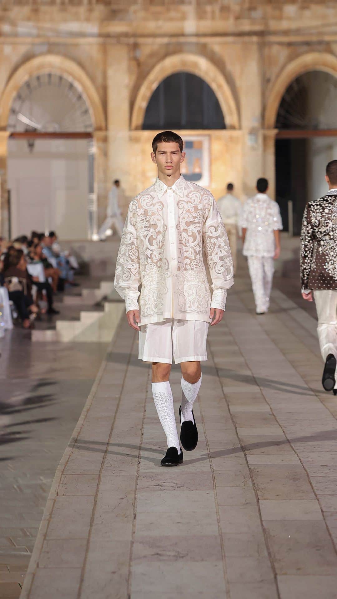 のインスタグラム：「The perfect synthesis of craftsmanship and heritage as the #DolceGabbana event unfolds in the breathtaking backdrop of Ostuni, the renowned ‘White City’ in Puglia. Nestled amidst the whitewashed lime buildings, the #DGAltaSartoria creations find harmony with the town’s rich history and artistic culture, capturing the essence of #MadeInItaly and #DGFattoAMano.    This shirt weaves mesmerizing light and shadow with floral motifs on crisp silk taffeta, reminiscent of Puglia’s alleys. Crafted with extreme precision, it features a base of pure silk organza, elegantly accentuating the flowers’ curves.    #BeItalian」