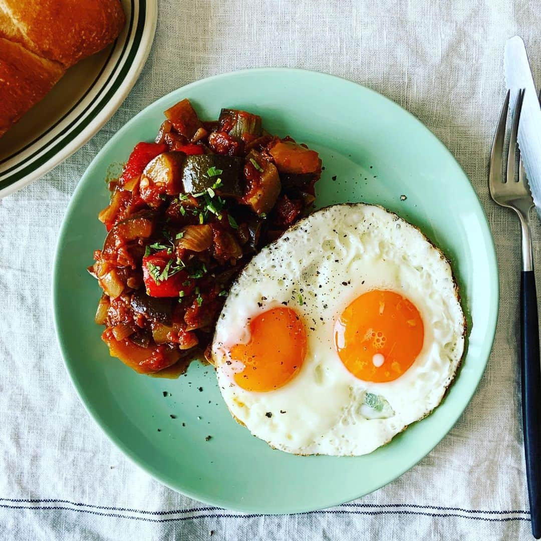 志摩有子さんのインスタグラム写真 - (志摩有子Instagram)「冷たいラタトィユに焼きたての目玉焼き。 とろけた黄身をからめて食すのがオツ。  ちなみにラタトゥイユの作り方のご質問があったので、我が家のレシピを。 玉ねぎ1個を1センチ角に切ってニンニクのみじん切りと塩ひとつまみとたっぷりのオリーブオイルで透明になるまで炒めたところにズッキーニ１本、ナス２本、パプリカ（赤、黄色）全部角切りにして加えて汗をかくまで炒めたところに、トマトの水煮缶1缶分を加え、あればローリエやオレガノなども加え、ハワイトバルサミコ大さじ1〜2、塩胡椒で味を調えててフタをして煮込むだけ。 出来たても美味しいけれど、この時期は冷たくするのが最高。  #夏野菜 #夏野菜レシピ #ラタトゥイユ #ラタトゥイユレシピ」7月12日 11時58分 - ariko418