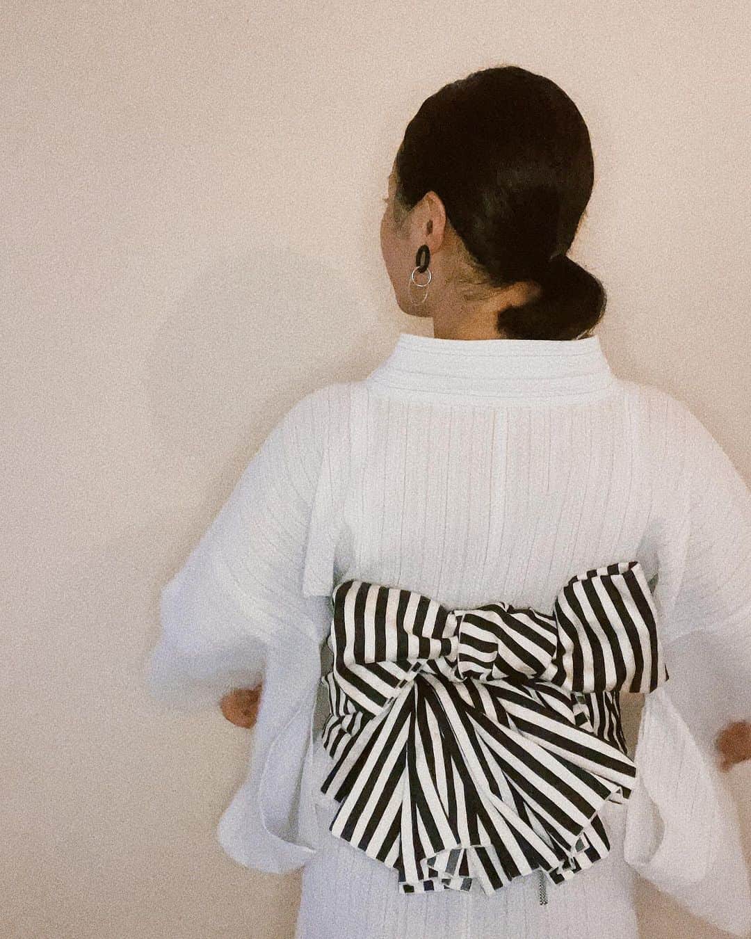 二宮愛のインスタグラム：「今日の #浴衣 🤍  しじら織の白くて涼しげな浴衣に、 ストライプ柄の兵児帯🖤🤍🖤🤍  文庫結びにペプラム結びを合体させた、アレンジ結び。 モダンな雰囲気になったので、大きめのピアス。  なかなか良い組み合わせになったので、ヘビロテする🍙🦨🐼⚽️🥋🎹🖤🤍 ________________  #着物好きな人と繋がりたい #浴衣コーデ」