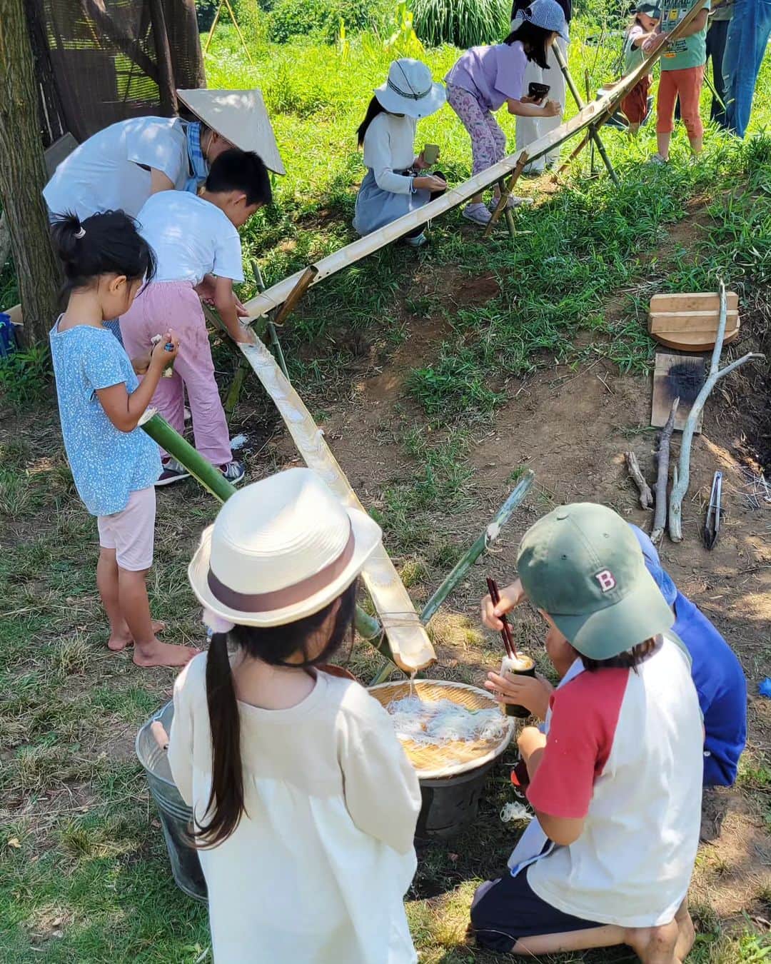 本仮屋リイナのインスタグラム：「長男念願の竹の手作り流しそうめん🎋⁡ ⁡家族だけではなかなか叶えてあげられずにいたのですが、オルタナティブスクールで実現できました✨(大感謝)⁡ ⁡⁡ 大人たちが竹をガシガシ切って、どんどん組み上げてゆく姿に熱視線を送りつつ、長男も負けじとノコギリを動かしてました。⁡  ⁡娘は、収穫&お料理担当🍅⁡ ⁡あぶなっかしい手つきに家ではつい口出ししてしまいますが、自然の中だと見守ってみようという気持ちになるのが不思議です。⁡⁡ ⁡⁡ ⁡汗だくになって働いた(わたしはほぼ傍観)あとの、⁡ ⁡キンキンに冷えた流しそうめん(大人は流さずザルから直に)は、⁡ ⁡格別でした🤝⁡ ⁡⁡ せっかく作った竹の器は、口径が小さすぎて麺がはみ出しまくり、子供たちから大ブーイング。すぐボツになりました🤗⁡ ⁡ ⁡#失敗込みで最高の思い出🍉」