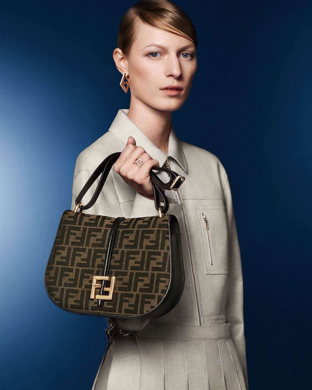 Fendiのインスタグラム：「An iteration of the new #FendiCmon satchel featuring the FF motif, symbol of the Maison since 1965, features alongside a ready-to-wear look with utilitarian references in the #FendiFW23 campaign.  The new collection is now available in boutiques and at Fendi.com.  Artistic Director of Couture and Womenswear: @mrkimjones​ Artistic Director of Accessories and Menswear: @silviaventurinifendi ​ Artistic Director of Jewellery: @delfinadelettrez​  Creative Direction: @ronnie.cooke.newhouse @karlbolander  Photography: @craigmcdeanstudio  Styling: @themelanieward Hair: @anthonyturnerhair Makeup: @peterphilipsmakeup  Casting: @shelleydurkancasting Set Design: @alexanderbockstudio  Model: @isitnobis」