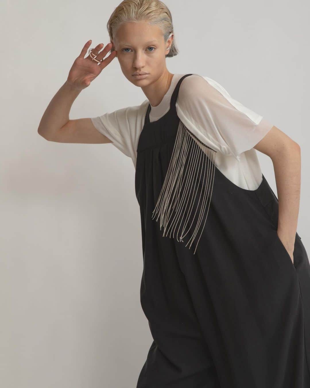 AULA AILAのインスタグラム：「【2023 HIGH SUMMER COLLECTION】  TACK SALOPETTE COLOR BLACK SIZE 0/1 ¥25,300   ワイドシルエットのリラックス感漂うサロペット。 リネンシルクのさらりとした素材感で、真夏にピッタリのアイテム。 胸元のディテールは、ホルターネックのような浅めでコンパクトな衿元にすることでカジュアル過ぎず、フェミニンで華奢な印象に。 裾は部分的にソフトオーガンジーをはめ込み透け感をプラス。  CHAIN FRINGE T-SHIRT COLOR OFF WHITE SIZE 0 ¥16,500  ボールチェーンのフリンジ付きのTシャツ。 左胸から垂れるフリンジは、動くと揺れてアクセサリーが付いているようなデザイン。  フリンジはドットボタンで簡単に取り外したり付けたりできるので、スタイリングやシーンに合わせてであったり、お洗濯の際に外してお手入れして頂けます。 襟ぐりと左肩から袖は、シアーチュールで切り替えて、肌が透けるので、フリンジを外しても素敵なデザインTシャツ。  ✔️AULA AILA OFFICIAL WEB STOREにて HIGH SUMMER COLLECTIONアイテム展開中！」