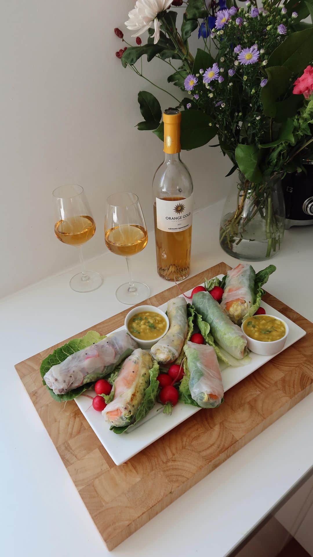 サンヌ・ヴロートのインスタグラム：「I’m loving this European summer. I am hosting a few friends, and I am going to treat them with this delicious aperitif with the Orange Gold wine from @gerardbertrandofficial   I’ve served this wine numerous times at dinner parties, and everyone is in LOVE with it! To complement the Orange Gold wine’s fresh and subtle notes, I paired it with these Chicken Curry Spring rolls. This recipe originates from Goop Kitchen, and I can’t get enough of them. It’s SO good. The curry flavor pairs perfectly with the fresh and subtle taste of the @orangegoldwine. Trust me, level up your summer aperitif with this combo:   Curry Spring Rolls w/ homemade Mango Chutney Mango Chutney:  1 cup diced pineapple  1/2 cup diced mango ( small pieces)  2 tbsp honey  2 tbsp rice wine vinegar  1 tsp curry powder  2 tbsp chopped cilantro  Zest and juice of 1 lemon   Curry Chicken Salad:  1/4 cup mayonnaise or vegainase  2 tsp curry powder  1/4 tsp turmeric  1/2 tsp salt  2 tbsp chopped cilantro  2 poached or roasted chicken breast  Zest and juice 1/2 lime  Fresh pepper  Wraps - Rice spring roll wrappers  Alfafa sprouts , lettuce and veggie you like like carrots, radish, avocado, pepper.   #gerardbertrand #orangegold #orangegoldsunset #organicorangewine」