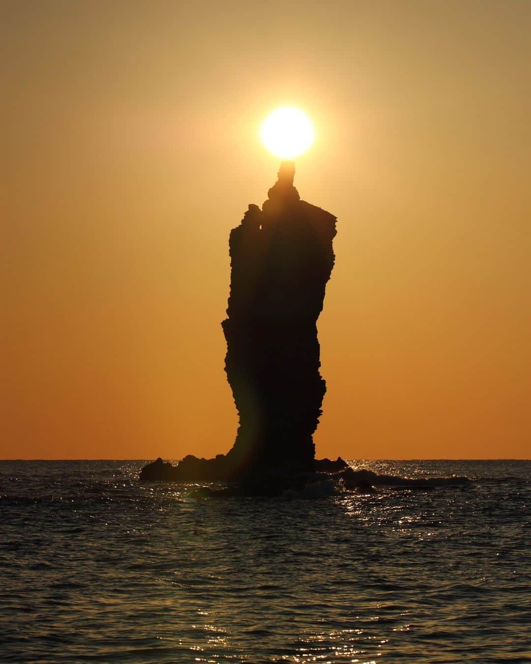 日本の国立公園のインスタグラム：「Capture the Unique Candle Island Sunset 🌅🕯️  Dreaming of a picture-perfect sunset? Candle Island (Rosoku-jima), a majestic rock formation rising about 20m out of the Sea of Japan, will impress even the most seasoned sunset-viewer. As the sun sets, it aligns with the top of the rock, resembling a lit candle for a fleeting moment. 🔥🌞  For the ultimate photo op of this stunning illusion, autumn is your go-to season. From September to October, you have a higher probability of catching a stunning sunset since the differences in temperature are moderate compared to spring and summer. Rainfall also improves air quality, making the lighting of the candle even more impressive if you can catch the sunset shortly after it rains. 😲🌧️  To experience the magic of Candle Island, hop aboard a cruise boat operating from March to November. Sail past the towering cliffs and sea caves until you reach the main event: the dazzling lighting of the candle sunset. 🚢📸  Drop a 🕯️ in the comments if you're excited about Candle Island!  📍 Candle Island, Shimane  📸 The sun set “lighting the candle” on Candle Island  #NationalParksJP #DaisenOkiNationalPark #OkiIslands #CandleIsland #Shimane #SeaOfJapan #SunsetMagic #LightTheCandle #GoldenHour #RockFormation #FallVibes #NaturePhotography #BestSunsets #Japan #JapanTravel #Tourism #ExploreJapan #DiscoverJapan #VisitJapan #日本 #国立公園」