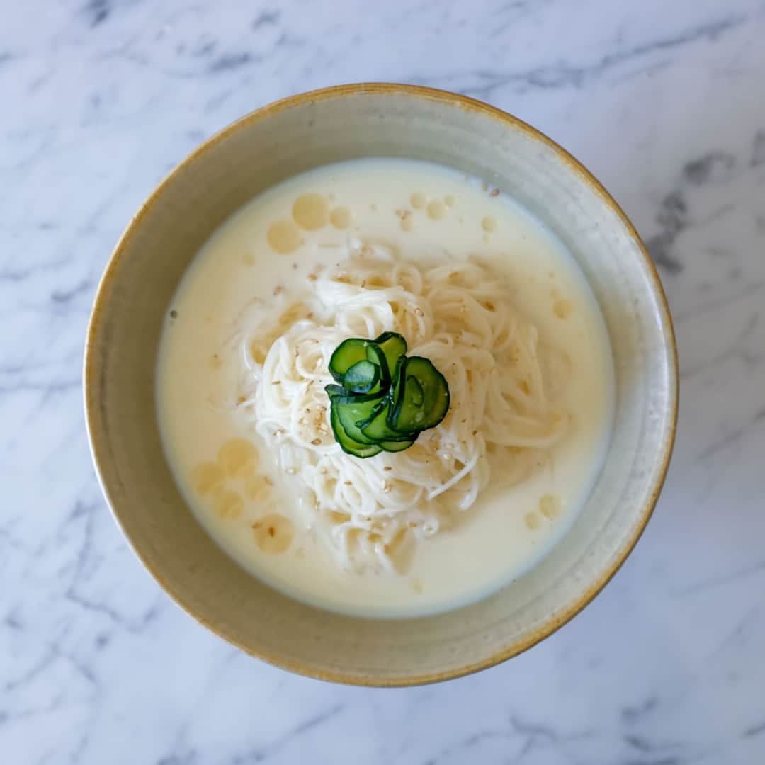 北欧、暮らしの道具店さんのインスタグラム写真 - (北欧、暮らしの道具店Instagram)「食欲がない日でも、これなら食べたい！「豆乳おだしの胡麻そうめん」 . - - - - - - - - - - - - - - - - - -  厳しい暑さが続いていますね……！ そんな夏日な食卓の救世主といえば、 やっぱり「そうめん」。  ささっと調理ができて、つるっと食べられる。 どのご家庭でも、 夏場は常にストックしている食材ではないでしょうか。  そこで今回は、東京・国立にて 「food common」を営む戸村沙絵さんに いつものそうめんとはひと味違う、 新しいお助けレシピをご紹介します。  ぜひランチや夜ご飯に作ってみてくださいね！ . - - - - - - - - - - - - - - - - - - - - - - - とことんシンプルなのが、ちょうどいい 「豆乳おだしの胡麻そうめん」 - - - - - - - - - - - - - - - - - - - - - - - 【材料（2人前）】 そうめん…200g（おおよそ2把） きゅうり…1/4本 塩…ひとつまみ 白ごま…適量 胡麻油…小さじ1程度  ＜つゆ＞ 豆乳…280ml 白だし（あごだし風味のものがおすすめ）…40ml  白だしは可能であれば 「あごだし」のものを使うと、 風味がよく、 より上品な味わいになるのでおすすめです。 煮干しだしも相性がいいそう。  もしご自宅に白だしがない場合は 麺つゆでも代用できますが、 色合いや味が変わるため、 分量はお好みで調整してください。  【作り方】 ❶白だしと豆乳をまぜた、豆乳だしを冷やしておく。  ❷きゅうりは薄くスライスし、 塩ひとつまみと合わせて塩もみする。 水気が出てきたら、絞っておく。  ❸そうめんはパッケージの表示の時間通りにゆで、 流水でよく洗い、水気を切る。 器にそうめん・きゅうりを盛り、 豆乳だしを流し入れる。  ❹仕上げに白ごまと、 風味づけの胡麻油をふって完成です。  - - - - - - - - - - - - - - - - - - - - - - - ■沙絵さん： 「これは冷たい豆乳だしのつゆに、 胡麻の風味を効かせた、 とことんシンプルなそうめんレシピです。  あえてシンプルに仕上げることで 食欲がないときにも食べやすく、 豆乳を使うことで小腹を満たすのにもちょうどいい、 そんな一皿になっています。  キリッと冷やして食べるので、猛暑日など、 暑すぎてもう何もしたくない！という日にもおすすめですよ」  このそうめんを見たときに感じたのは、 なんて美しいレシピなんだろう、ということ。  そうめん自体の味わいがシンプルなので、 つい色々のせたくなってしまうのですが、 この潔さには惚れ惚れ。  香りも味わいも優しくまろやかで、 暑さにまいってしまった日にこそ、 大変おすすめです。  #food#ごはん#レシピ#夜ごはん#ディナー#ランチ#時短料理#foodcommon さん#そうめん#素麺#シンプル#シンプルライフ#シンプルデザイン#暮らしを楽しむ#日々の暮らし#北欧#暮らし#北欧暮らしの道具店」7月14日 17時04分 - hokuoh_kurashi