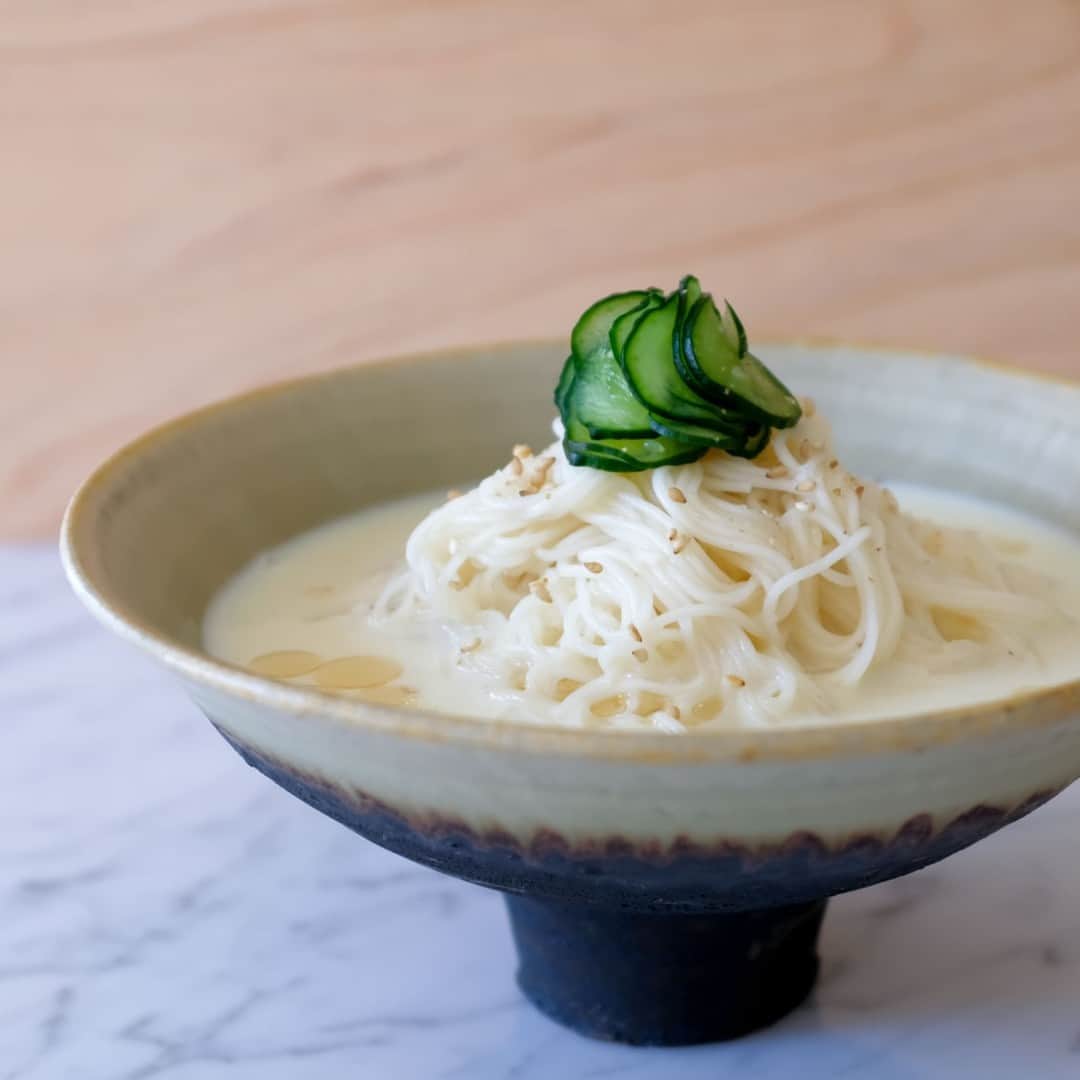 北欧、暮らしの道具店さんのインスタグラム写真 - (北欧、暮らしの道具店Instagram)「食欲がない日でも、これなら食べたい！「豆乳おだしの胡麻そうめん」 . - - - - - - - - - - - - - - - - - -  厳しい暑さが続いていますね……！ そんな夏日な食卓の救世主といえば、 やっぱり「そうめん」。  ささっと調理ができて、つるっと食べられる。 どのご家庭でも、 夏場は常にストックしている食材ではないでしょうか。  そこで今回は、東京・国立にて 「food common」を営む戸村沙絵さんに いつものそうめんとはひと味違う、 新しいお助けレシピをご紹介します。  ぜひランチや夜ご飯に作ってみてくださいね！ . - - - - - - - - - - - - - - - - - - - - - - - とことんシンプルなのが、ちょうどいい 「豆乳おだしの胡麻そうめん」 - - - - - - - - - - - - - - - - - - - - - - - 【材料（2人前）】 そうめん…200g（おおよそ2把） きゅうり…1/4本 塩…ひとつまみ 白ごま…適量 胡麻油…小さじ1程度  ＜つゆ＞ 豆乳…280ml 白だし（あごだし風味のものがおすすめ）…40ml  白だしは可能であれば 「あごだし」のものを使うと、 風味がよく、 より上品な味わいになるのでおすすめです。 煮干しだしも相性がいいそう。  もしご自宅に白だしがない場合は 麺つゆでも代用できますが、 色合いや味が変わるため、 分量はお好みで調整してください。  【作り方】 ❶白だしと豆乳をまぜた、豆乳だしを冷やしておく。  ❷きゅうりは薄くスライスし、 塩ひとつまみと合わせて塩もみする。 水気が出てきたら、絞っておく。  ❸そうめんはパッケージの表示の時間通りにゆで、 流水でよく洗い、水気を切る。 器にそうめん・きゅうりを盛り、 豆乳だしを流し入れる。  ❹仕上げに白ごまと、 風味づけの胡麻油をふって完成です。  - - - - - - - - - - - - - - - - - - - - - - - ■沙絵さん： 「これは冷たい豆乳だしのつゆに、 胡麻の風味を効かせた、 とことんシンプルなそうめんレシピです。  あえてシンプルに仕上げることで 食欲がないときにも食べやすく、 豆乳を使うことで小腹を満たすのにもちょうどいい、 そんな一皿になっています。  キリッと冷やして食べるので、猛暑日など、 暑すぎてもう何もしたくない！という日にもおすすめですよ」  このそうめんを見たときに感じたのは、 なんて美しいレシピなんだろう、ということ。  そうめん自体の味わいがシンプルなので、 つい色々のせたくなってしまうのですが、 この潔さには惚れ惚れ。  香りも味わいも優しくまろやかで、 暑さにまいってしまった日にこそ、 大変おすすめです。  #food#ごはん#レシピ#夜ごはん#ディナー#ランチ#時短料理#foodcommon さん#そうめん#素麺#シンプル#シンプルライフ#シンプルデザイン#暮らしを楽しむ#日々の暮らし#北欧#暮らし#北欧暮らしの道具店」7月14日 17時04分 - hokuoh_kurashi