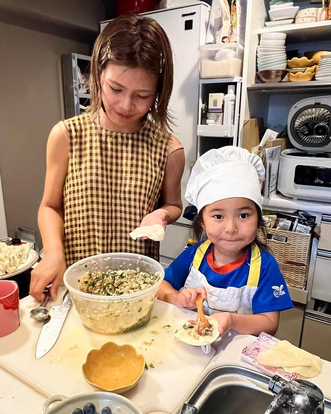 クロのインスタグラム：「一緒にお料理楽しい👩🏽🤎👧🏽 さっちゃんの満足気な顔が見られるのも良き。餃子は子どものお手伝いに最強ですね！ そしてブンブンチョッパーは、安全なのにやってる感あり☝🏽で、子どものお手伝いにいいな〜って思いました〜 私は動画撮るのに必死で画面越しでもたいして見てなくて、ブログの読者さんに、「さっちゃん包むの上手👏🏽👏🏽👏🏽」って教えてもらってちゃんと見たら、（👉🏽8枚目） めちゃくちゃ器用で… そこちゃんと褒めてあげられてたかな？（なんか上の空でいつもじょ！ずー！とかは言ってそうではある）とか思っちゃいました。 子育てしているとあちこちに気持ちが分散して、さらに私は常にブログ書いたり仕事にも追われていたりするので、目の前のことに全集中をもっともーっと意識しつつ、まあほどほどにちゃんと愛していけたらいいなと思います🤎🤎🤎（どっち）  #母娘 #親子でお料理 #ちびクロdiary」