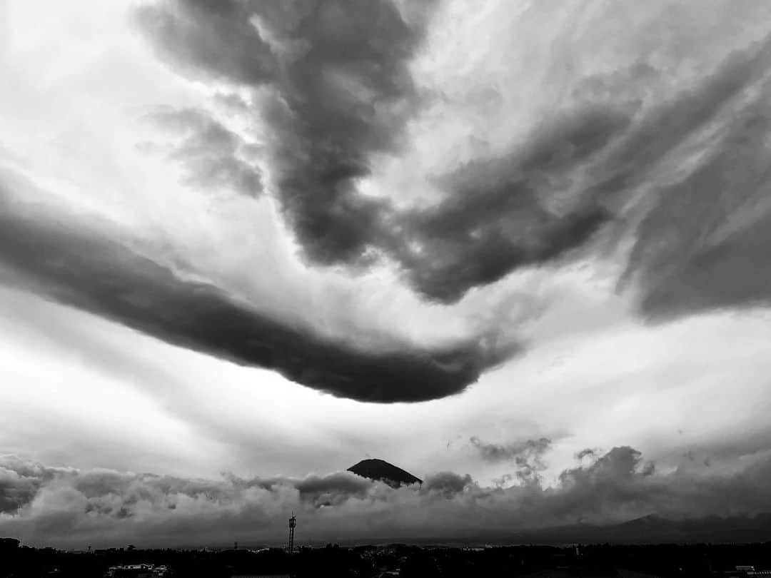 和田美枝のインスタグラム：「お天気が良くなくて、しっかりと現れなかったけれど、、、  雲と富士山の先っちょコラボ。  モノクロで撮ると水墨画みたいで、これはこれで、よい🗻  #富士山 #モノクロ #水墨画」