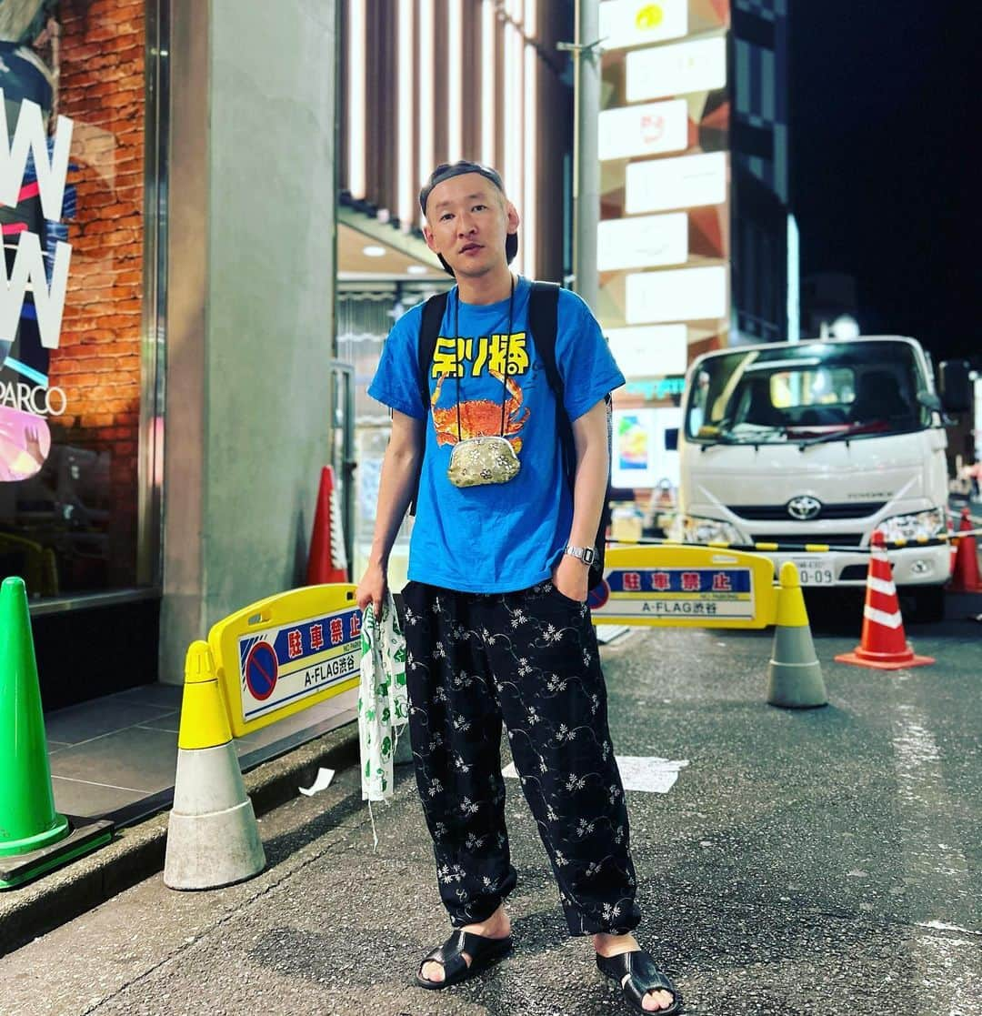 市川刺身さんのインスタグラム写真 - (市川刺身Instagram)「今日の服装。 渋谷でライブ。 合間と終わりにネタ合わせ明日は19時から遂にそいつどいつベストネタライブ『ジョーカー』です。 是非観に来てください。  色味が元気出る吊り橋ピュンの立派な蟹のTシャツ。 先日ウスノロで購入した花柄のイージーパンツ。 足首をブリヂストンのゴムで絞って。 十四才で購入した帽子に金のがま口mont-bellのメッシュリュック黒の便所サンダル手には手ぬぐい。  遂に明日全4回の新ネタワンマンでやったネタの中からのベストなネタをやるワンマンライブ『ジョーカー』 最後の最後まで。 今の僕らを観に来てやってください。 ネタ合わせ終わりに劇場出た所で社員の久喜さんに撮ってもらいました。 今月で退社する久喜さんとても撮るのが上手でした。 久喜さんありがとうございます。  #今日着た服 #ファッション #古着 #吊り橋ピュン #蟹 #渋谷 #金曜日 #人多い #腹減った」7月14日 23時48分 - soitsudoitsu