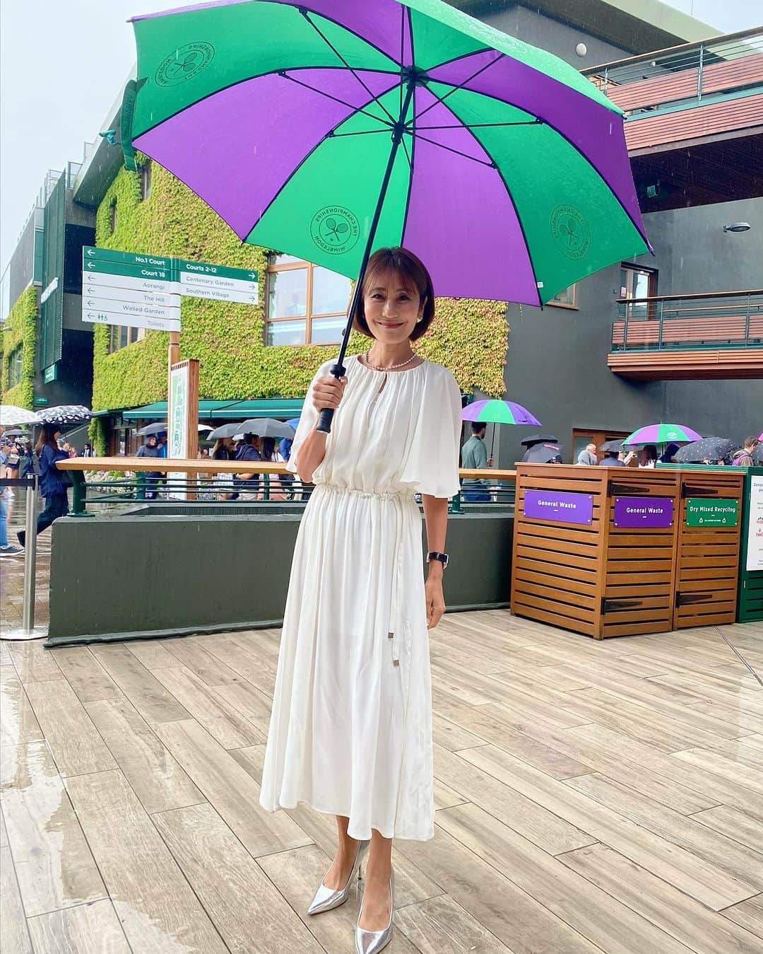 森上亜希子のインスタグラム：「今日は一日中雨でした☔️  男子シングルス準決勝2試合は屋根を閉じて行われました。 ジョコビッチ選手vs シンネル選手の試合は、シンネル選手も何とか食らいついていこうとしていたものの、「このゲームをブレークしたら楽だよね。」という所でしっかりブレーク、そしてまだまだ余裕あるよ。というプレー。グランドスラムで初めて準決勝を戦ったシンネル選手との経験の差を見せつけた感じでした。  もう一方の準決勝はアルカラス選手vs メドベージェフ選手  センターコートで試合を見ていましたが、アルカラス選手のリターンの素晴らしい事、そして、ストロークのボールの速いこと！ メドベージェフ選手のサーブに対しての反応も良かったし、レシーブからでも攻める姿勢。凄かったですね。  男子決勝はジョコビッチ選手vs アルカラス選手  うぅ、痺れるカードになりましたね！ 経験豊富なジョコビッチ選手か勢いがあるアルカラス選手か！  楽しみです！  さぁ、そして明日は女子シングルス決勝戦が行われます。  ボンドロウソバ選手 vs ジャバー選手  直近2大会の対戦成績は2-0でボンドロウソバ選手です。いずれもサーフェスはハードコート。  場所はウィンブルドン決勝の舞台。 初のグランドスラム決勝の舞台のボンドロウソバ選手、3度目のグランドスラムの決勝戦を戦うジャバー選手。  そして、芝がベストサーフェスではないボンドロウソバ選手、一方、芝が得意なジャバー選手。  どうなるのか！ 私もとても楽しみです！  NHKではLiveでお伝えする予定です。 是非、ご覧下さい！  本日の衣装です Styling by @mari_takarada   お袖がポイントの白のワンピース。 ウィンブルドンの傘が更にこの白を引き立ててくれます。  2枚目はセキュリティの可愛い女の子と。  Dress @livianacontiofficial   Shoes Zara (スタイリスト私物）  #wimbledon  #nhk #解説 #tennis #テニス #衣装紹介」